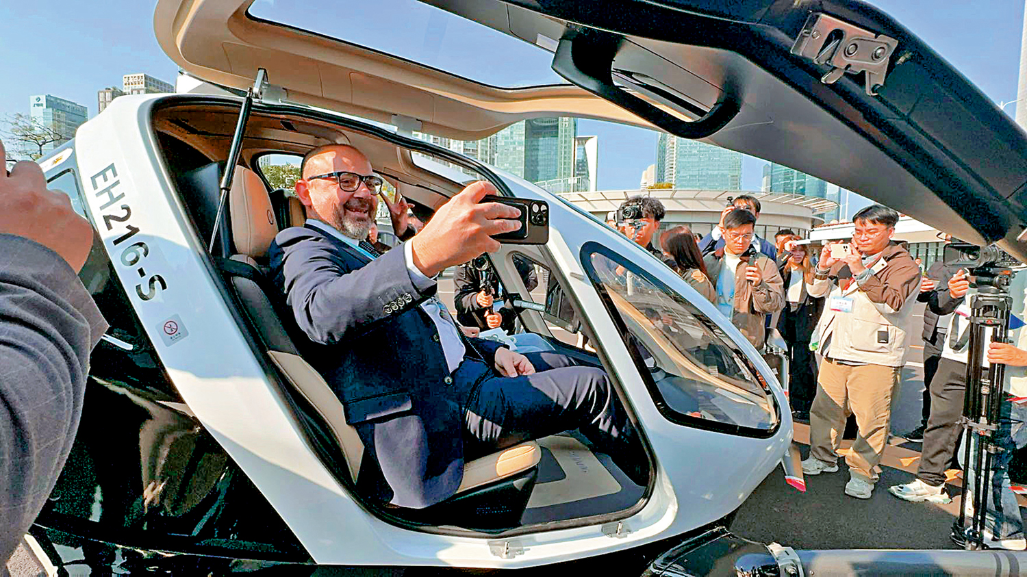 　　圖：2日，多位參會代表參與「千年商都·創新未來都市之旅」參訪活動。圖為參會嘉賓Gianpiero Antonazzo試坐無人飛行器。\大公報記者盧靜怡攝