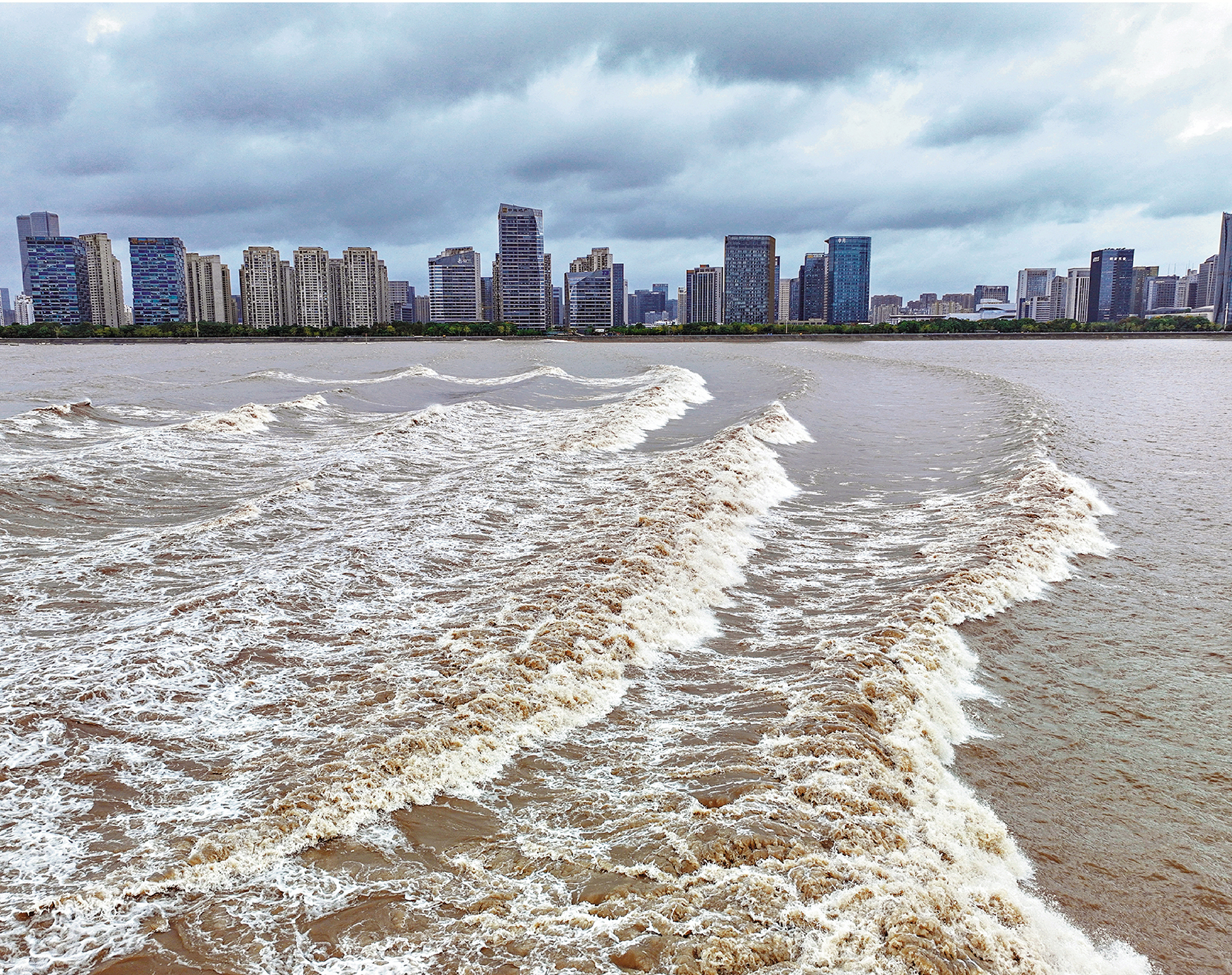 　　圖：當錢塘江大潮經過杭州市區時，潮水、大橋與兩岸林立的高樓組成了壯觀景象。/資料圖片