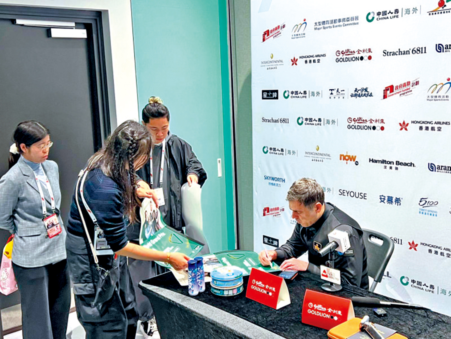 　　圖：奧蘇利雲（右）為球迷簽名。