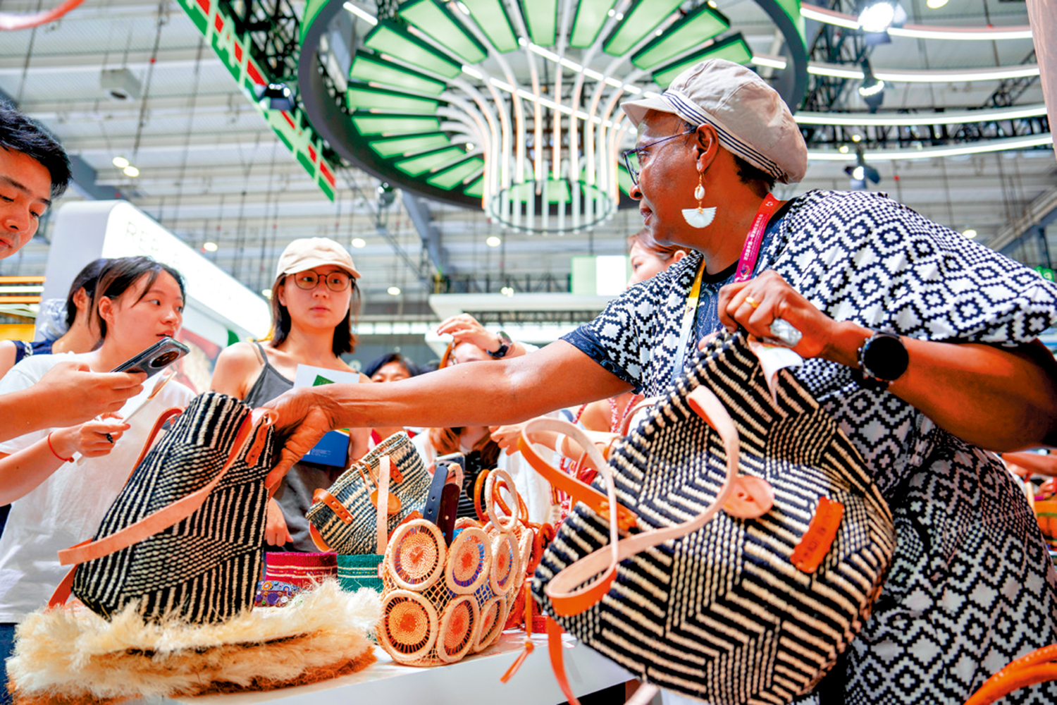 　　圖：在去年於湖南長沙舉行的第四屆中國—非洲經貿博覽會上，參展商（右一）向觀眾介紹非洲商品。\新華社