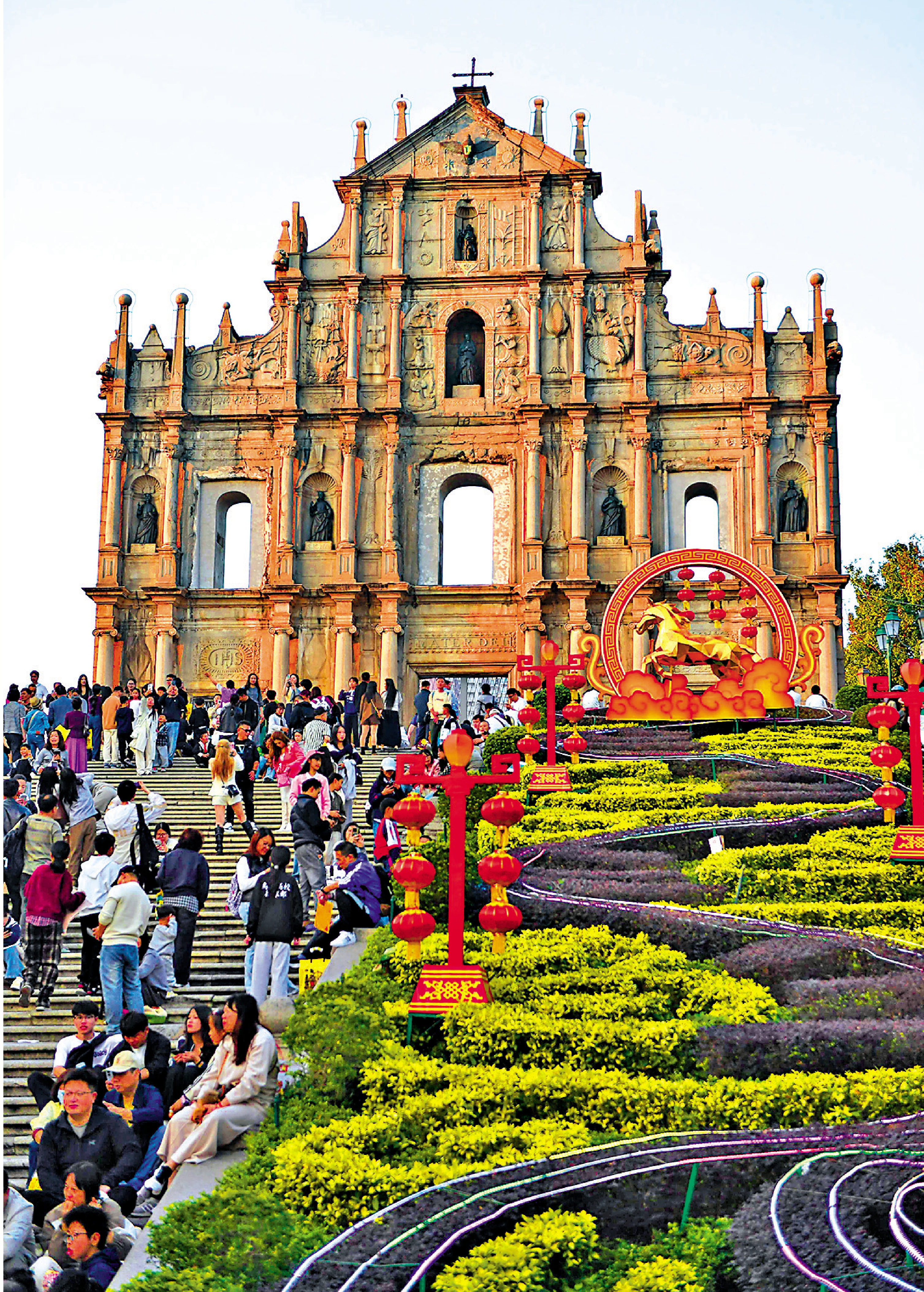 　　圖：澳門大三巴牌坊前遊人如織，一側的花叢中加裝了新春裝飾/中新社
