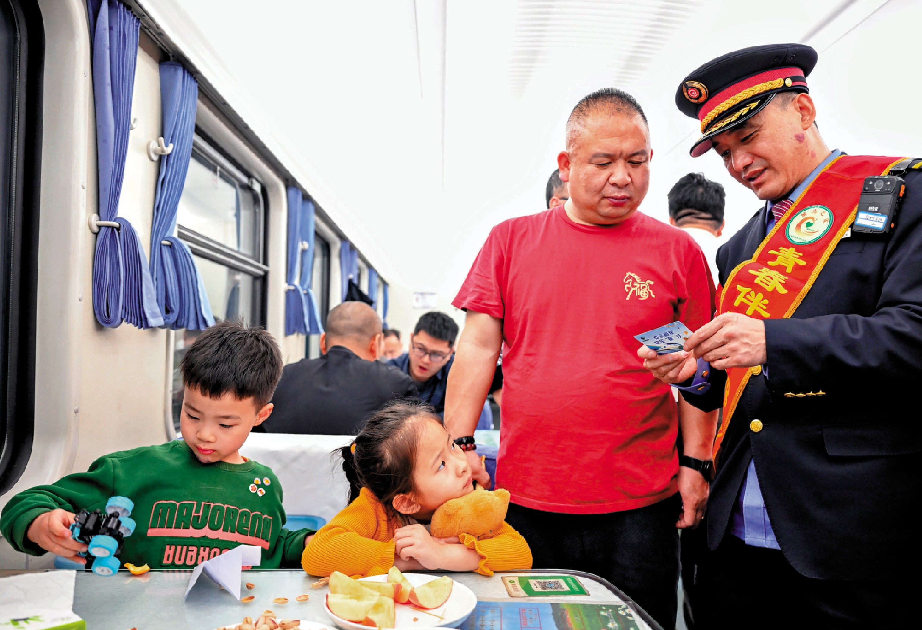 　　圖：15日，鐵路工作人員在車廂內向旅客發放兒童安全乘車溫馨提示卡。\新華社