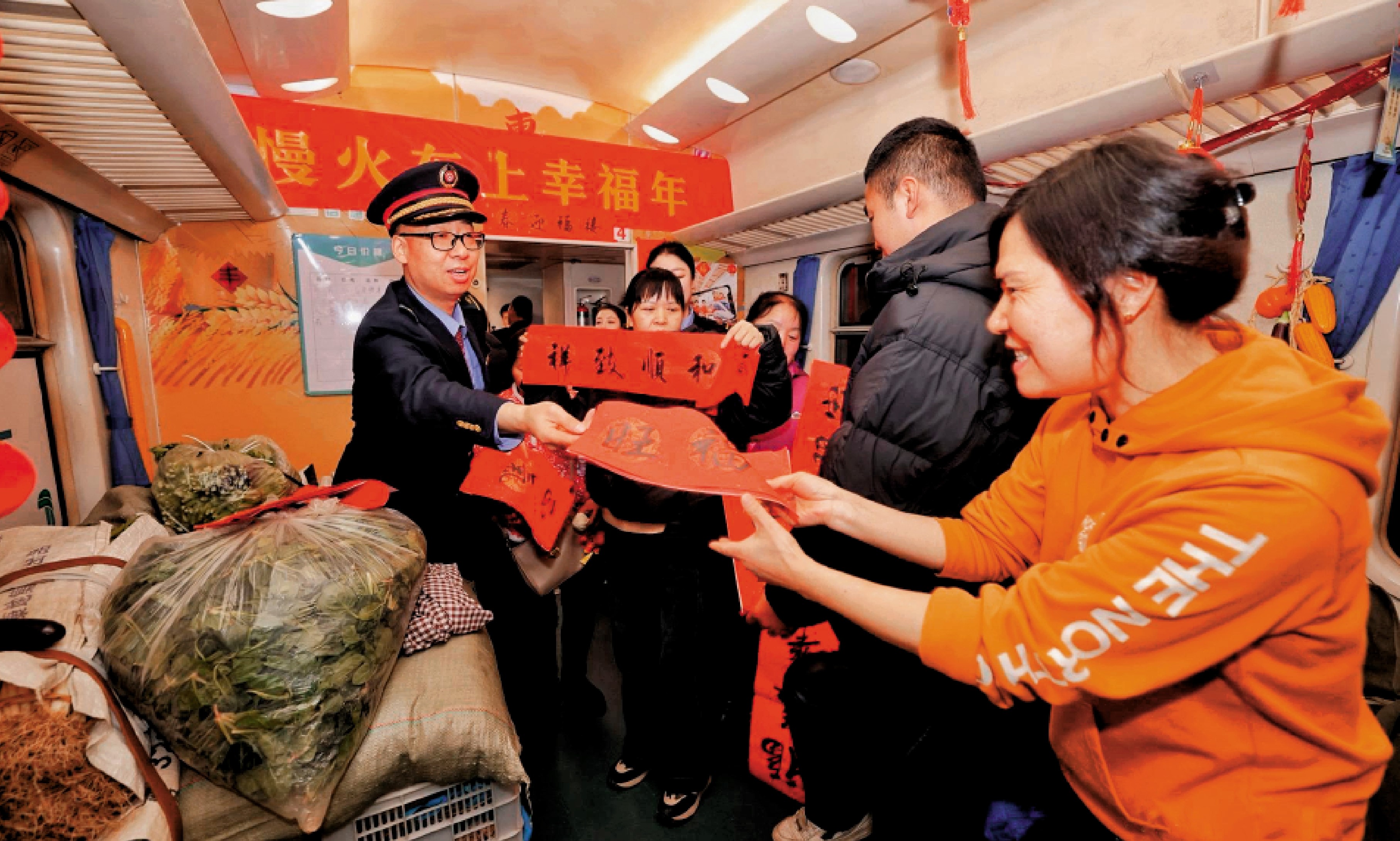 　　圖：鐵路工作人員在公益「慢火車」上向旅客發放春節祝福。