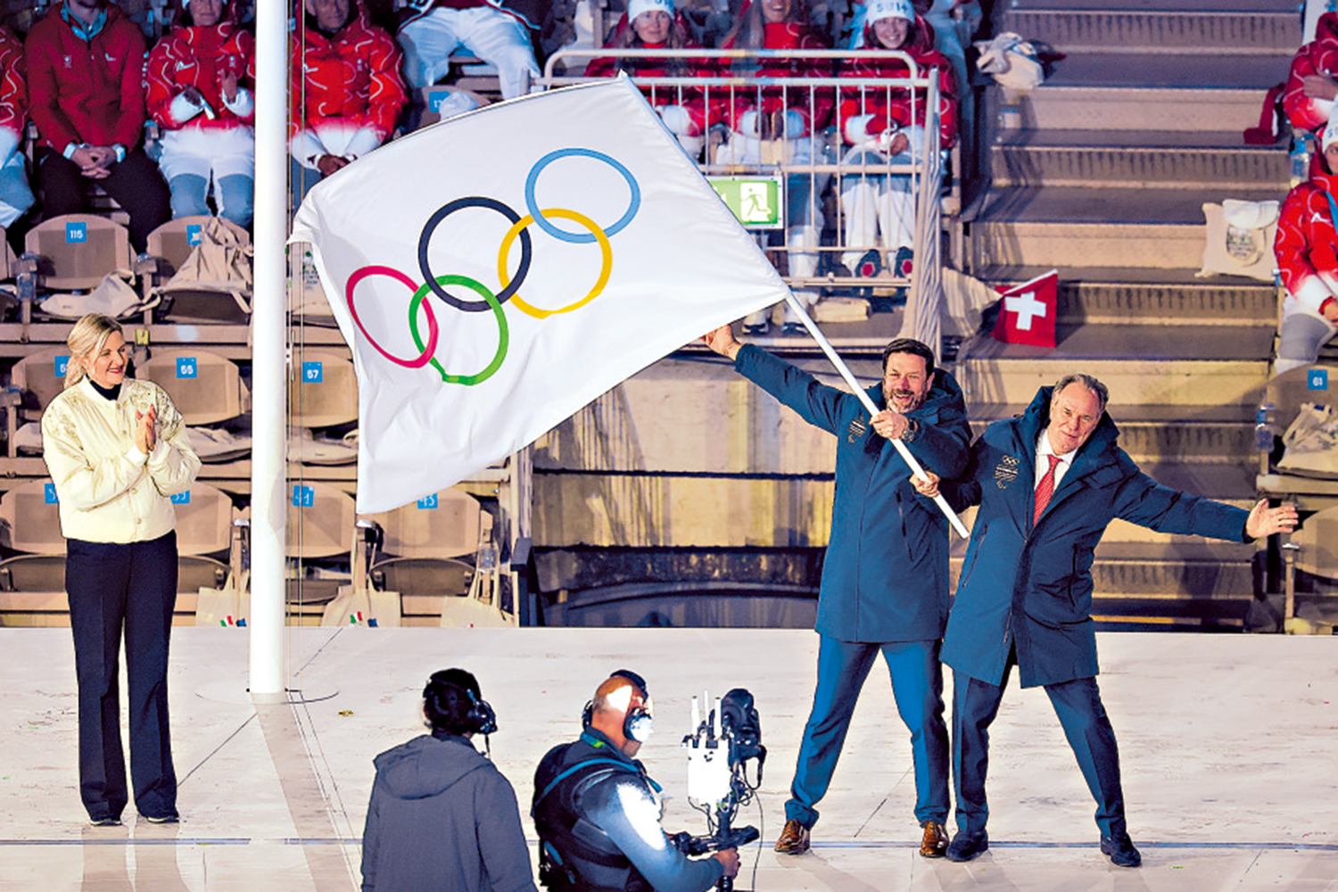 　　圖：考文垂（左一）和下屆冬奧舉辦地法國的代表在奧林匹克會旗交接儀式上。\中新社