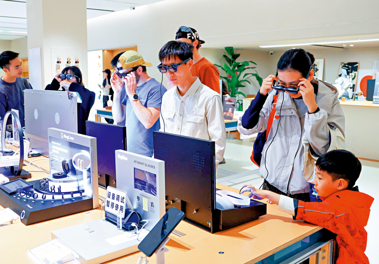　　圖：顧客在深圳市南山區的INNO100全球創新旗艦店體驗智能眼鏡。\新華社