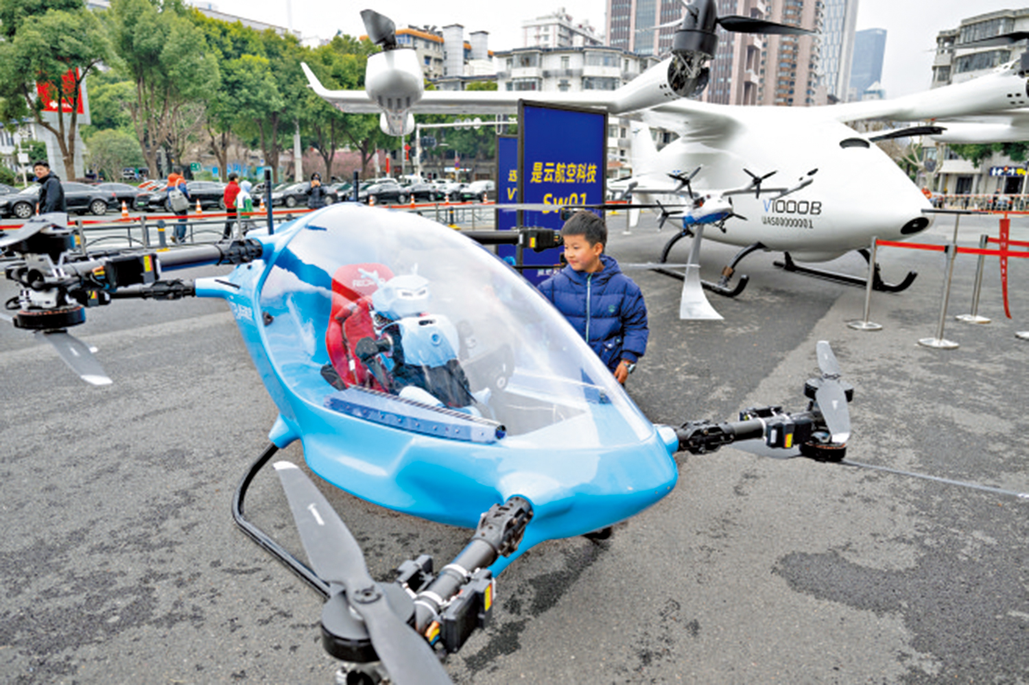 　　圖：「十五五」開局，航空航天等新的經濟增長點蓄勢待發。圖為小朋友在觀看國產eVTOL（電動垂直起降飛行器）航空器及人形機器人。\新華社