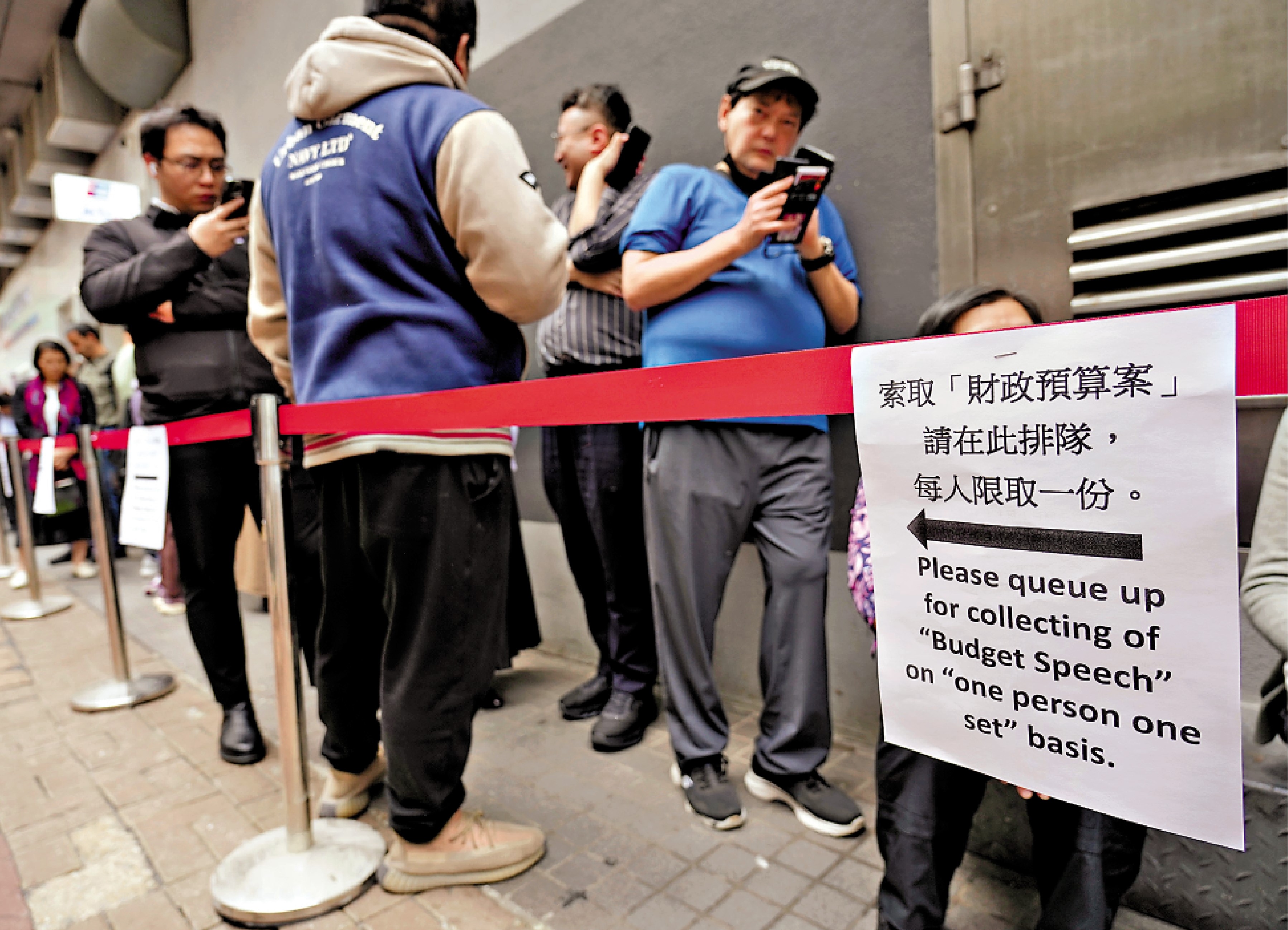 　　圖：市民關注財政預算案，排隊領取小冊子。\大公報記者麥潤田攝