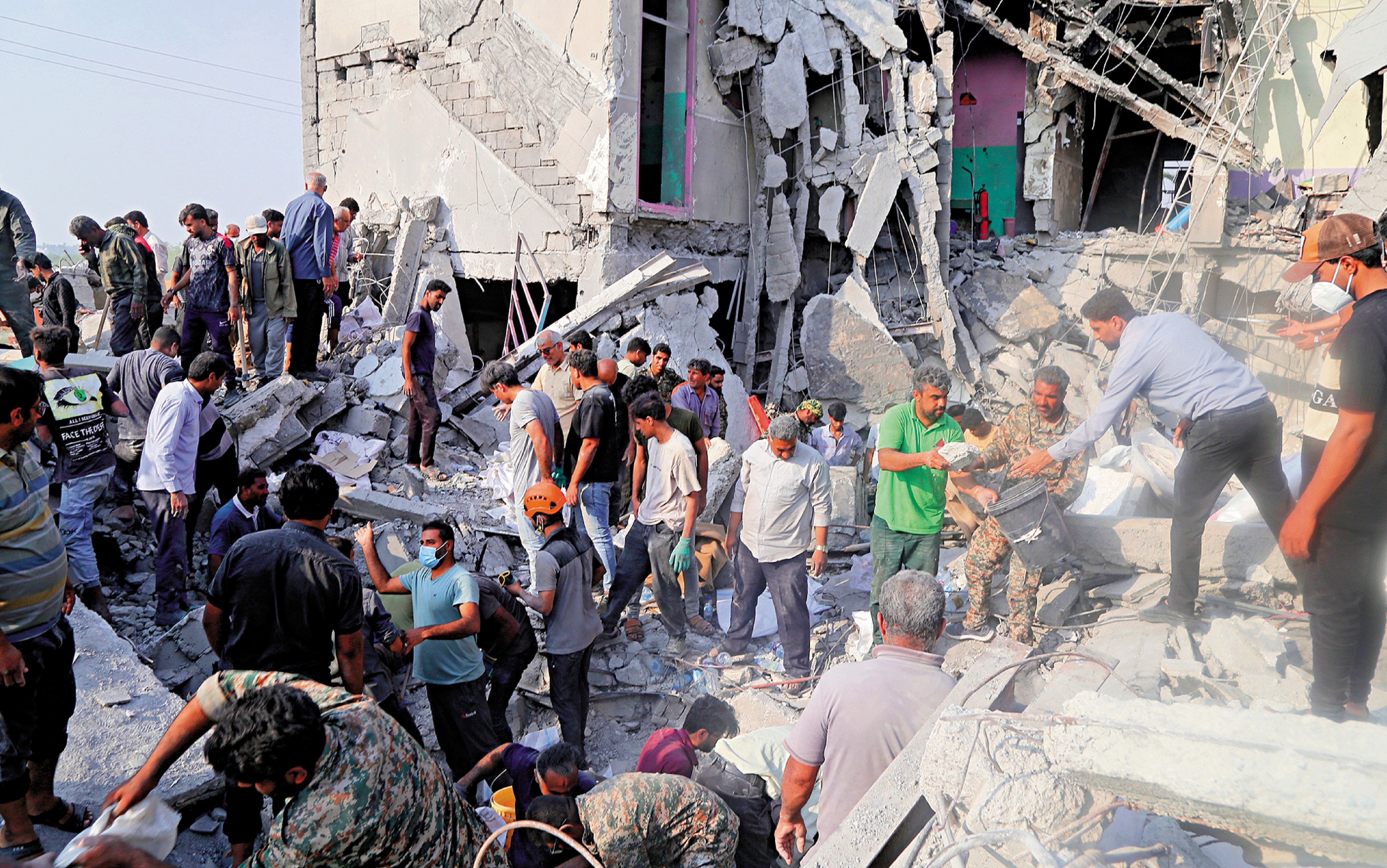 　　圖：美國和以色列對伊朗發起聯合軍事打擊，在伊朗米納卜市一所被襲擊的小學，造成重大人命傷亡，救援人員和當地居民試圖從廢墟裏營救傷員。\新華社