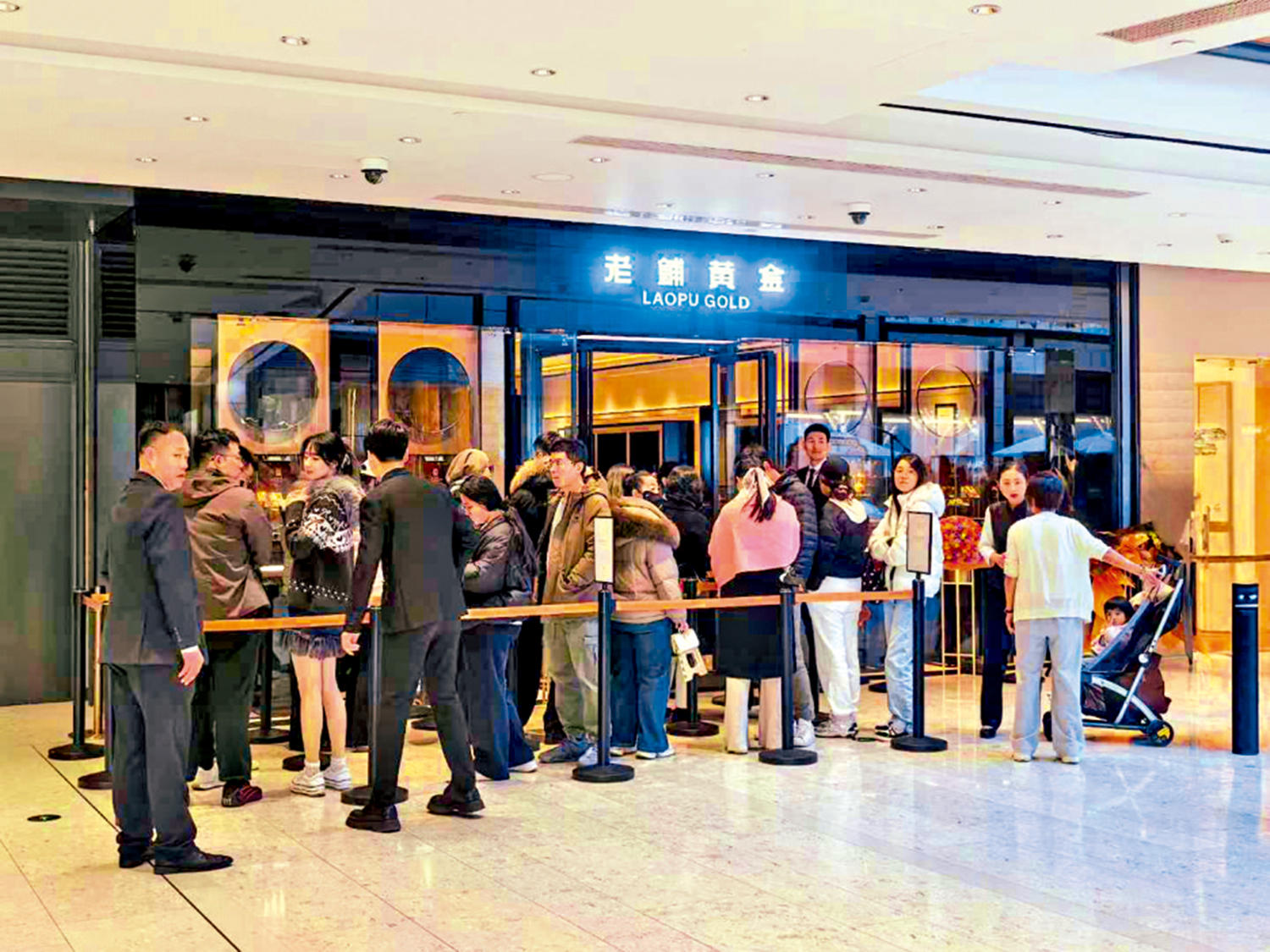 　　圖：購金熱情高漲，消費者在老鋪黃金門外排隊等候入店選購產品。\大公報記者毛麗娟攝
