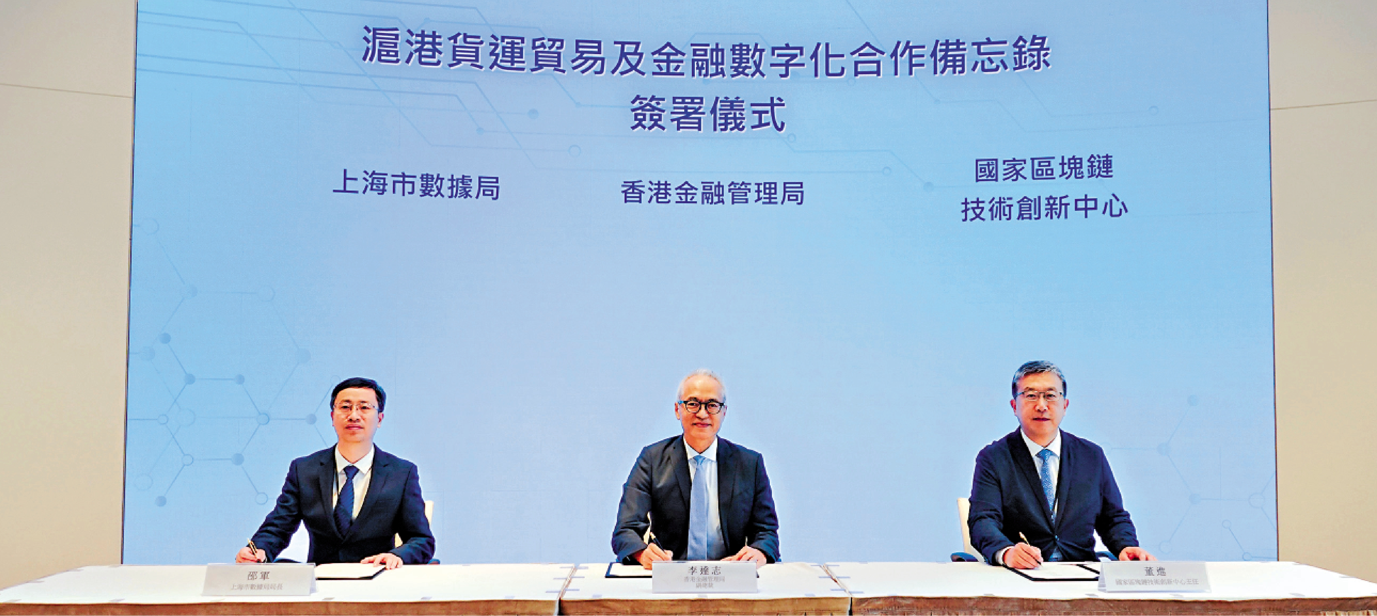 　　圖：香港金融管理局副總裁李達志（中）、上海市數據局局長邵軍（左）與國家區塊鏈技術創新中心主任董進（右）簽署合作備忘錄。