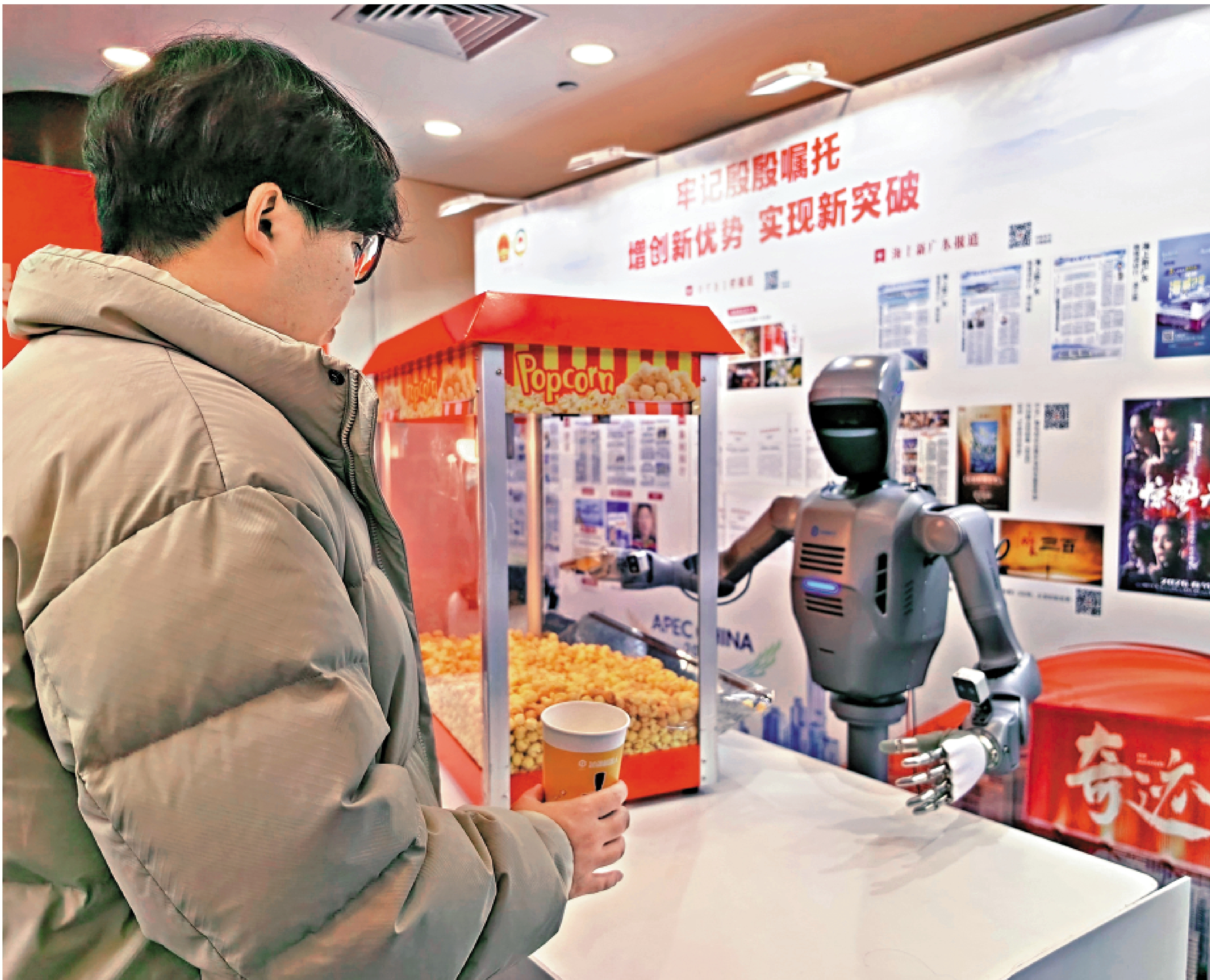 　　圖：人形機器人為市民裝爆米花，動作穩定準確。\大公報記者郭若溪攝