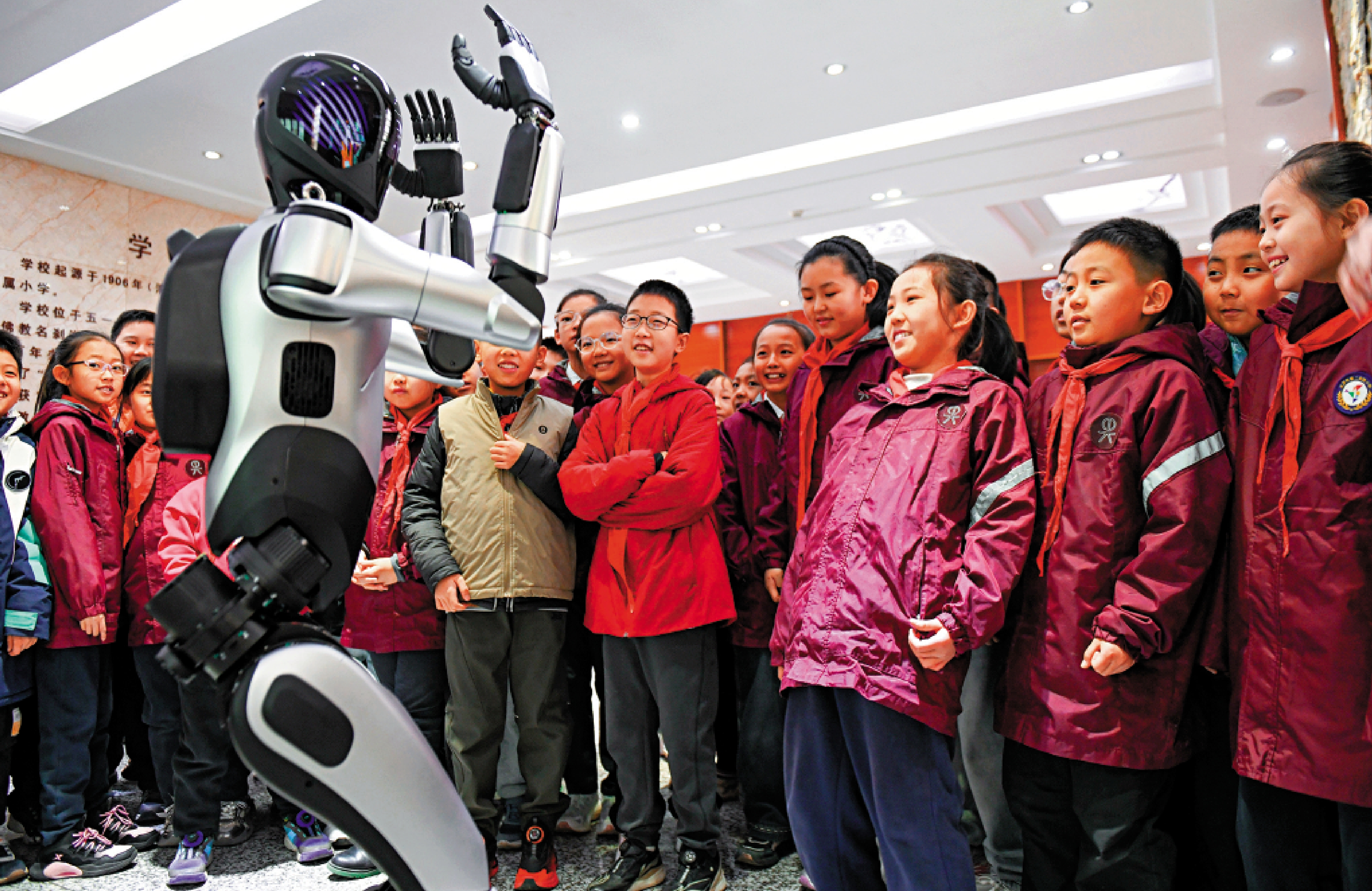 　　圖：人形機器人已可以靈活地唱歌跳舞、與人互動。圖為學生們與人形機器人互動。\中新社