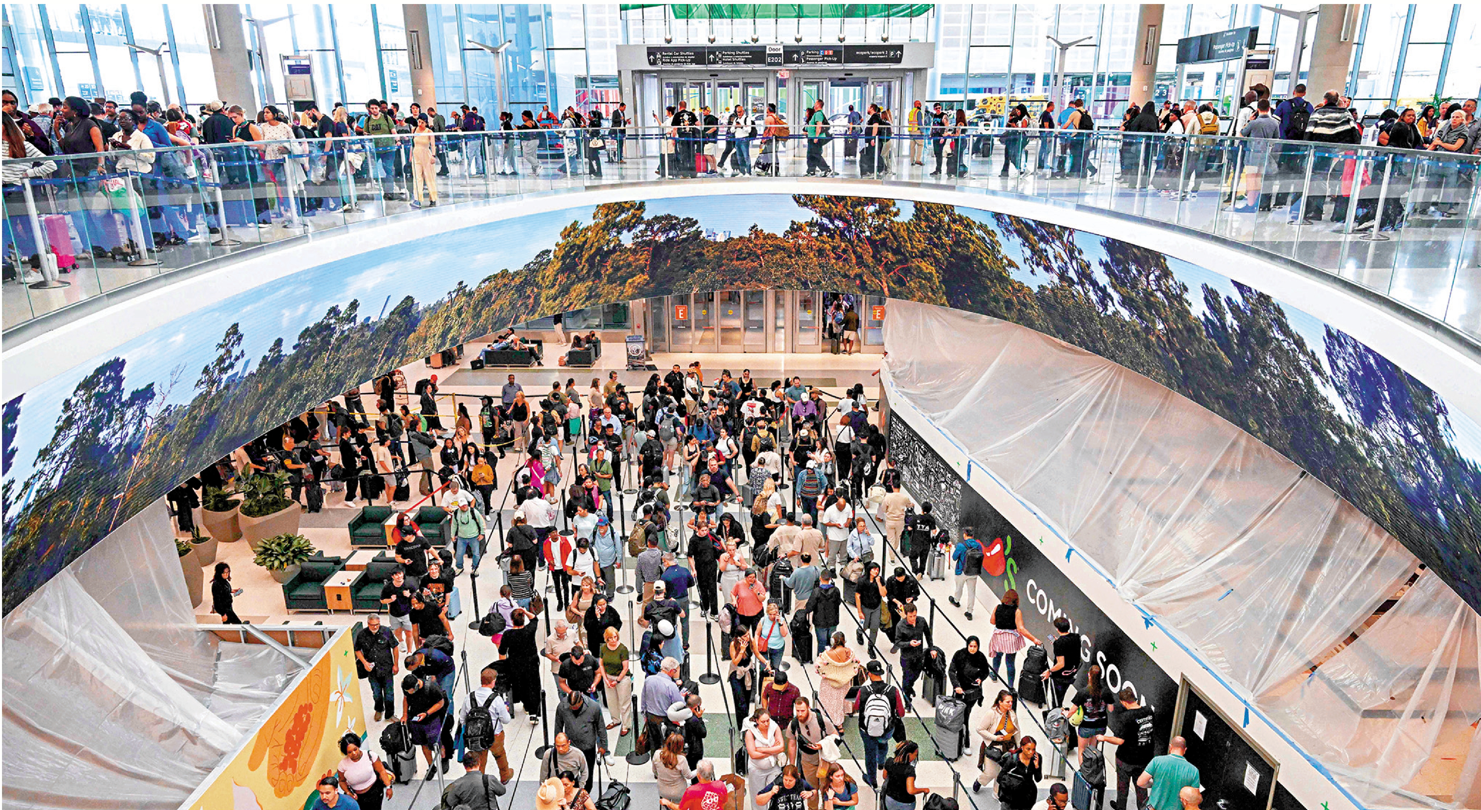 　　圖：美國休斯敦的喬治布什機場內，旅客們排着長隊等待安檢。\法新社