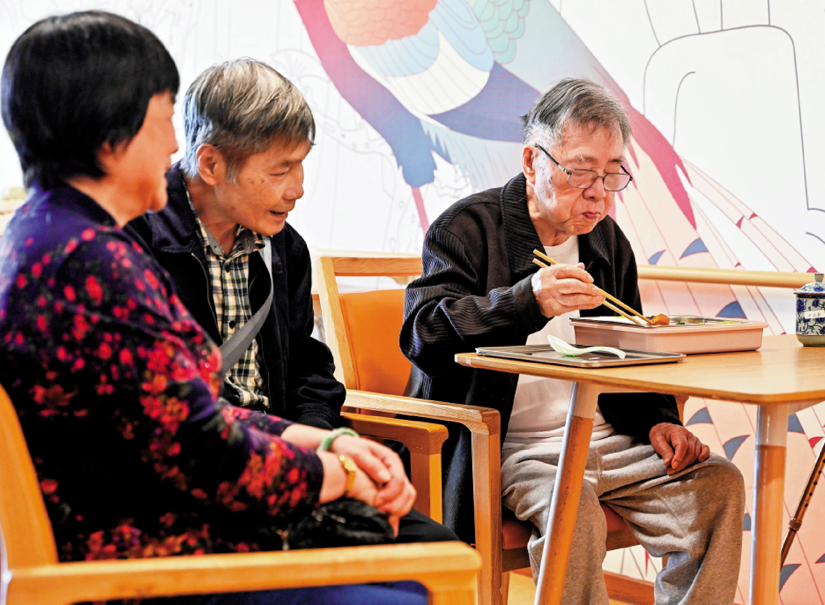 　　圖：居住在廣州頤壽安養麓湖家長薈的香港長者許叔（右）在家人的陪伴下享用午餐。\中新社