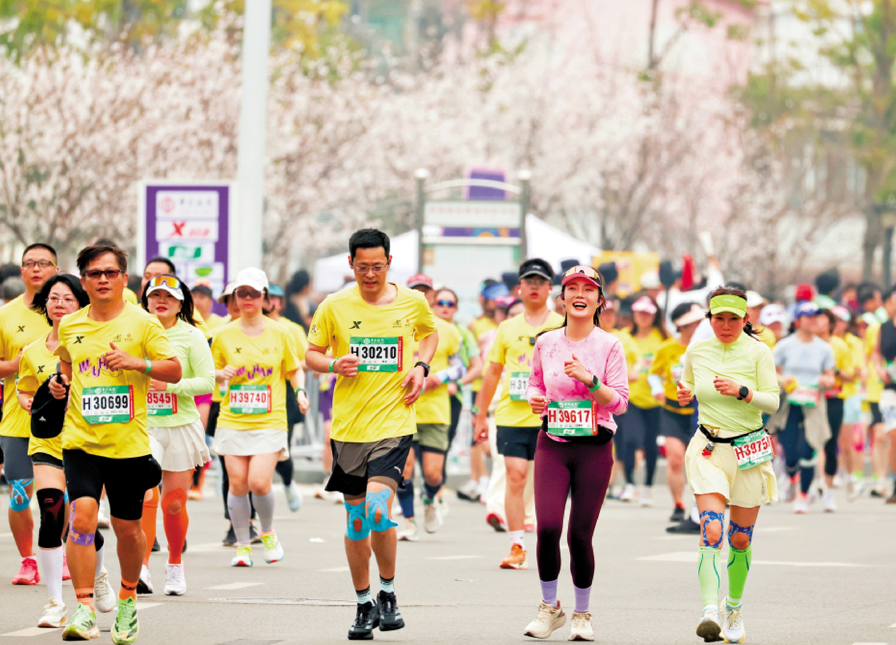 　　圖：今年武漢馬拉松，參賽選手跑過櫻花盛開的武漢街頭。\中新社