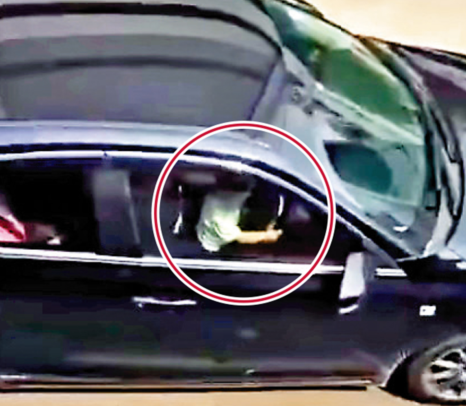 　　圖：一名小童（紅圈示）坐在司機大腿，雙手扭軚盤駕私家車，司機涉危駕被捕。