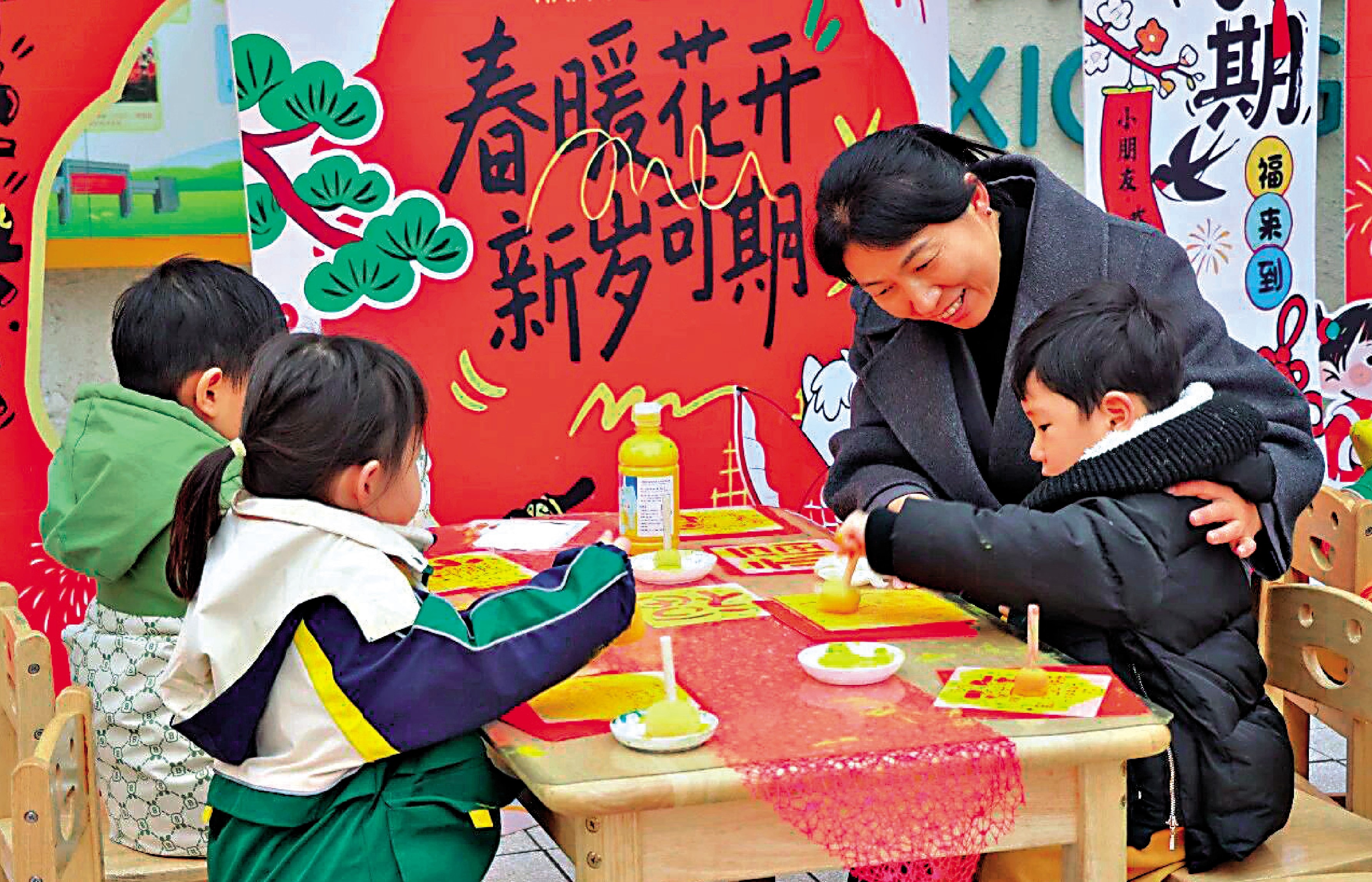 　　圖：雄安容和朝暉幼兒園的老師帶着孩子們拓印福字。