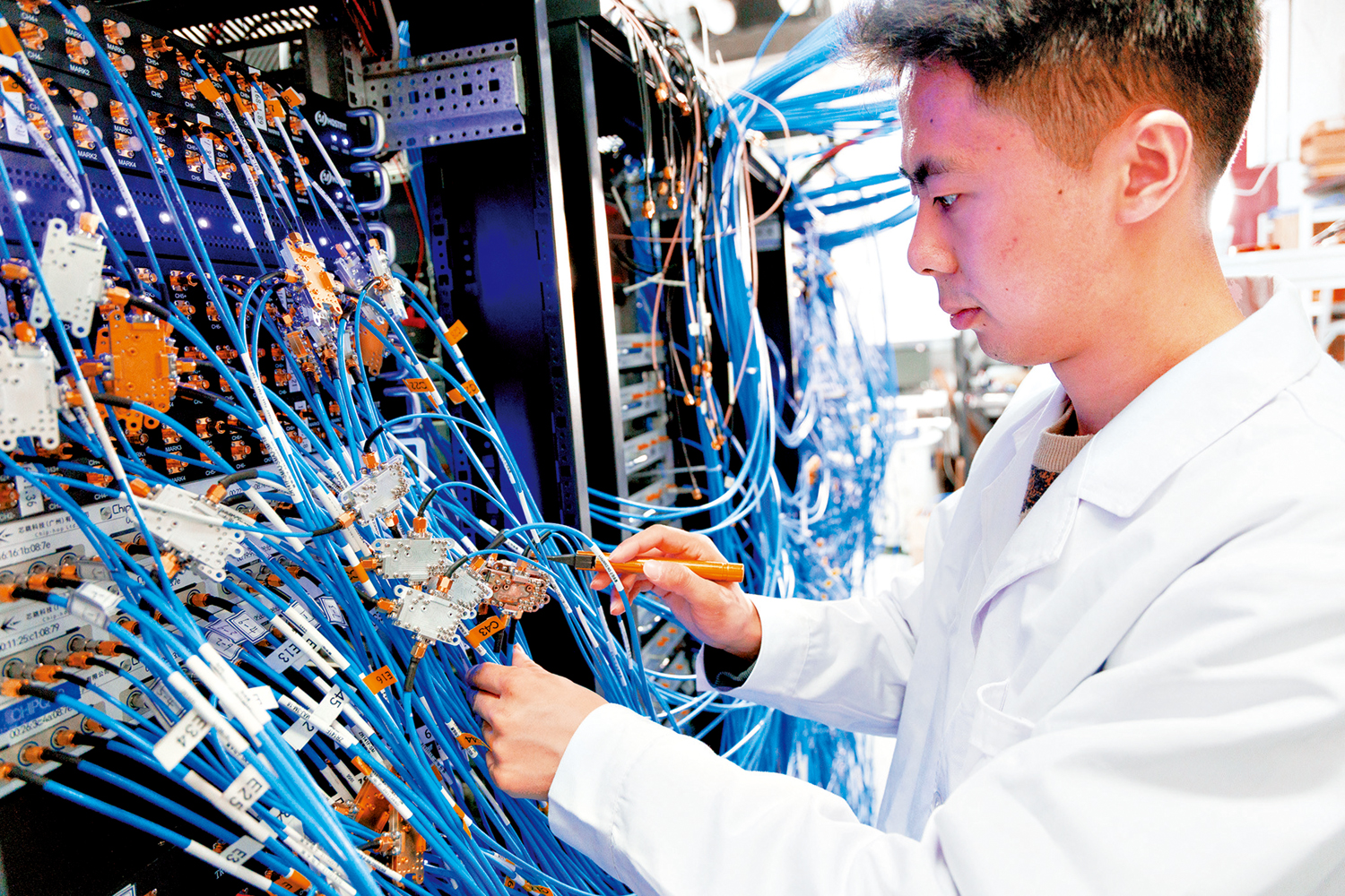 　　圖：中國正在由「論文大國」邁向「科技強國」。圖為1月21日，中國科學院學者正在實驗室操作測控接線。\新華社