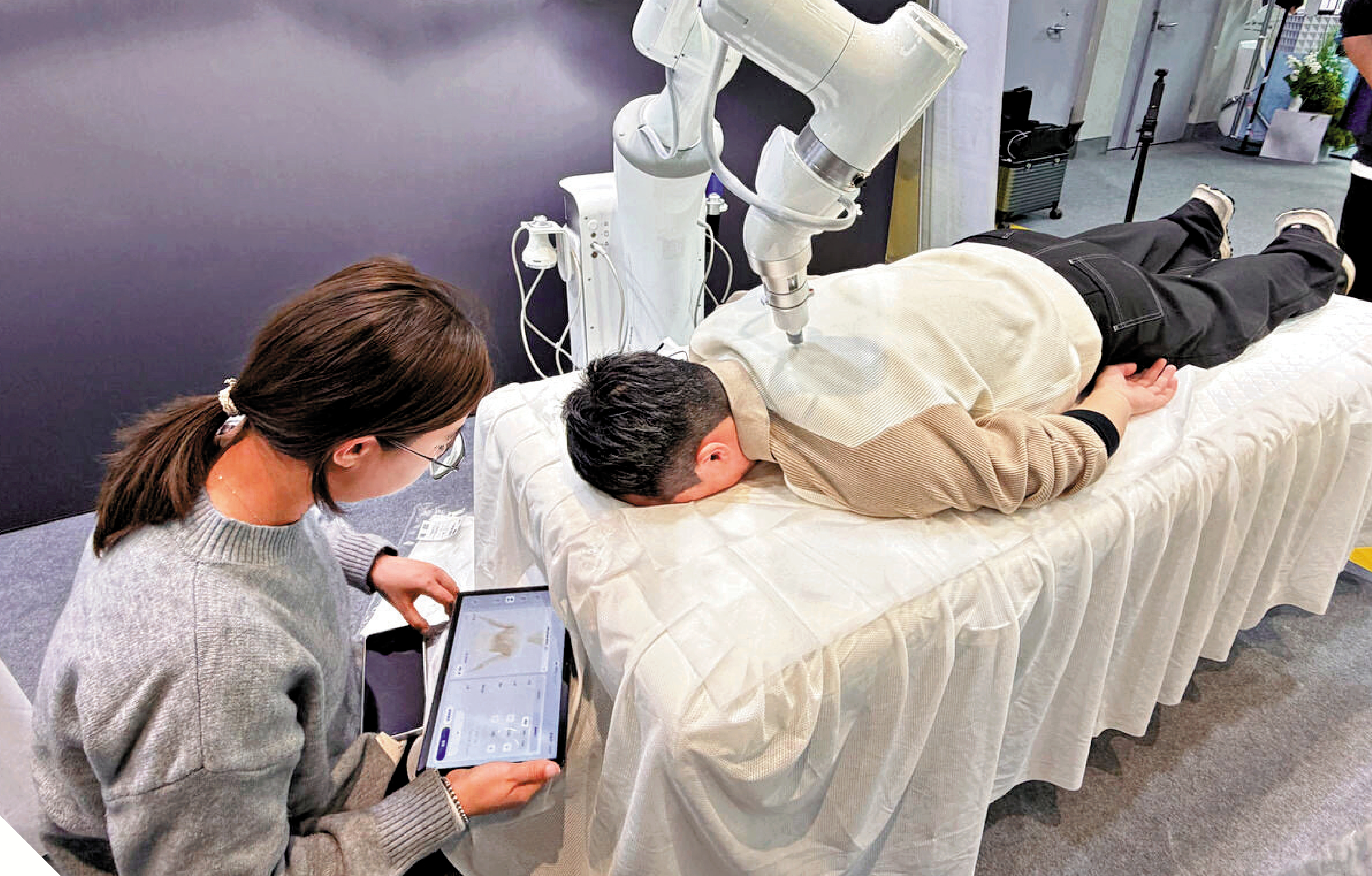 　　圖：當AI技術逐步從實驗室走向產業一線，「有用」比「酷炫」更具商業價值。圖為內地展會上智能按摩機器人獲得體驗者點讚。\大公報記者王莉攝