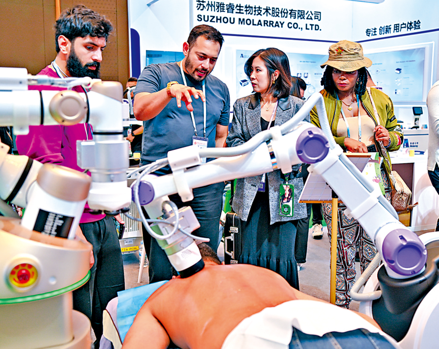 　　圖：外國客商在廣交會展館了解一款理療機器人。\新華社