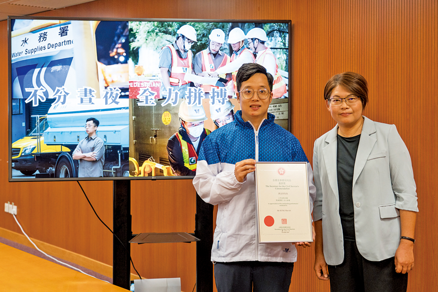 　　圖：水務署高級水務督察黃艷裳（右）讚許洪文杰表現。\公務員事務局提供相片