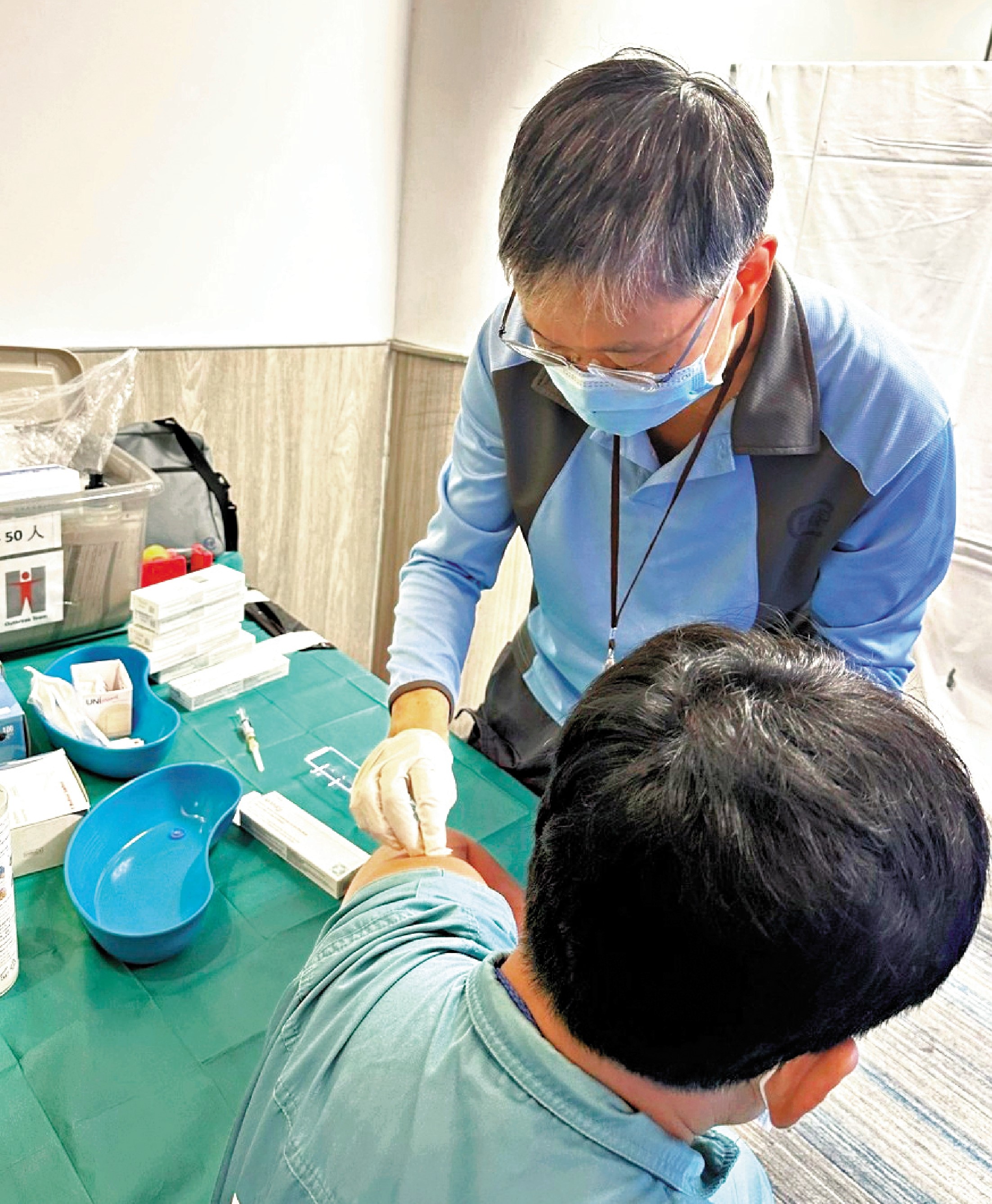 　　圖：衞生防護中心職員為在機場工作的密切接觸者進行評估及接種疫苗。
