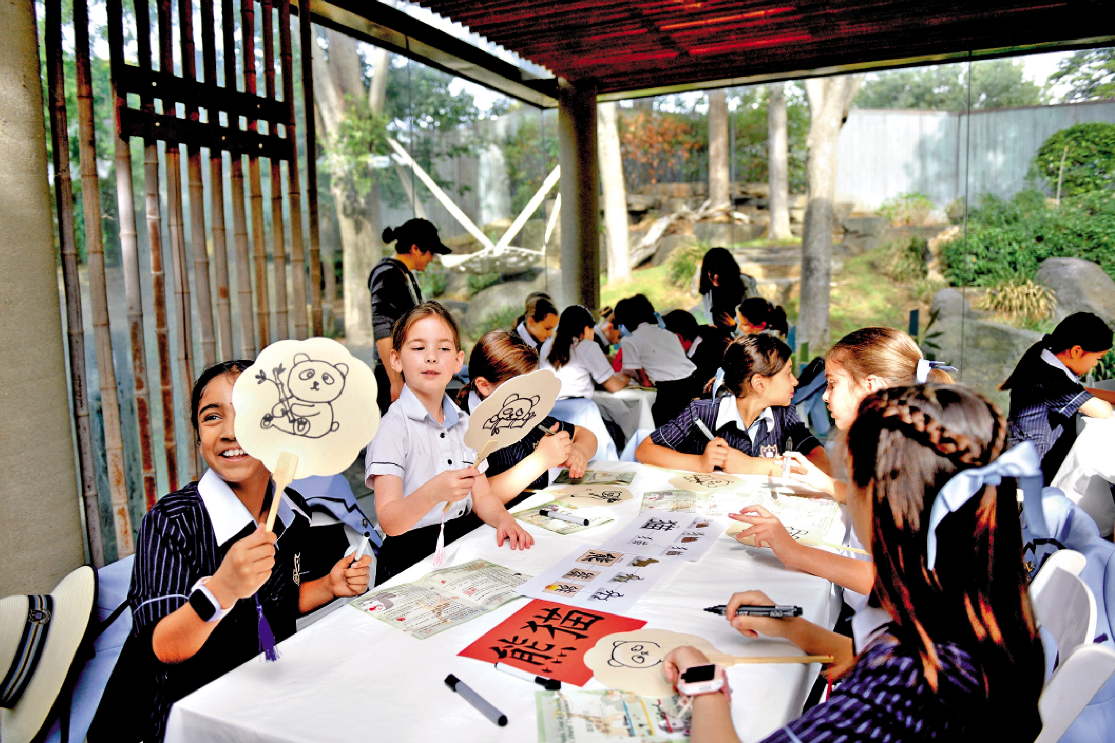 　　圖：4月2日，在澳洲阿德萊德動物園舉辦的「國際中文日」活動中，來自當地學校的學生書寫漢字「熊貓」並繪畫。\新華社