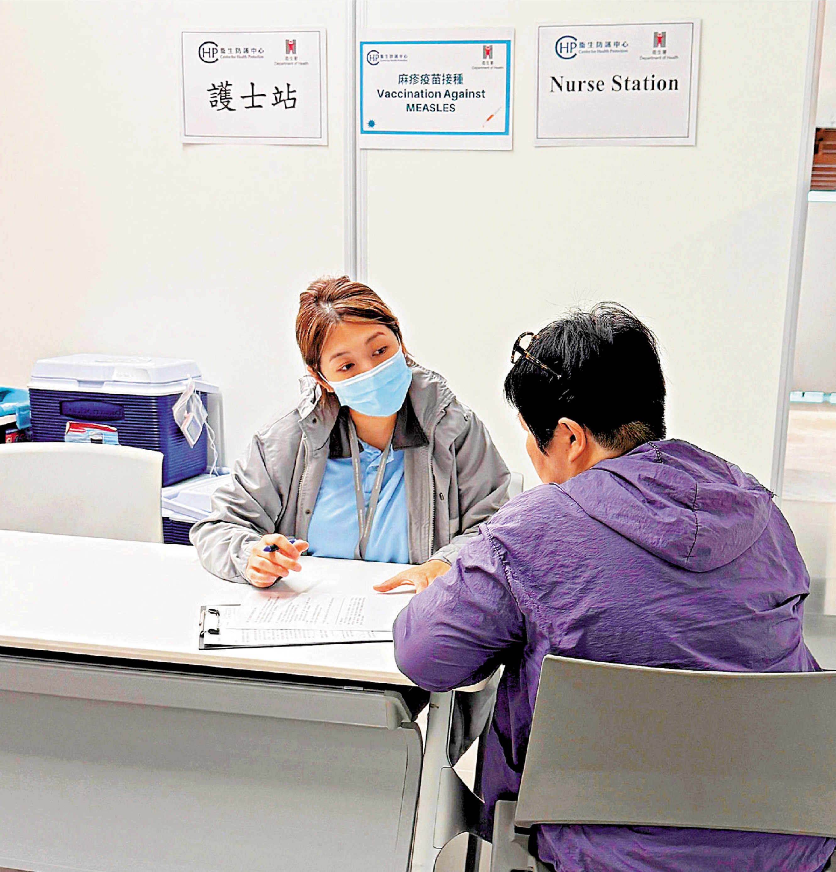 　　圖：衞生防護中心職員為機場員工於接種疫苗前作評估。