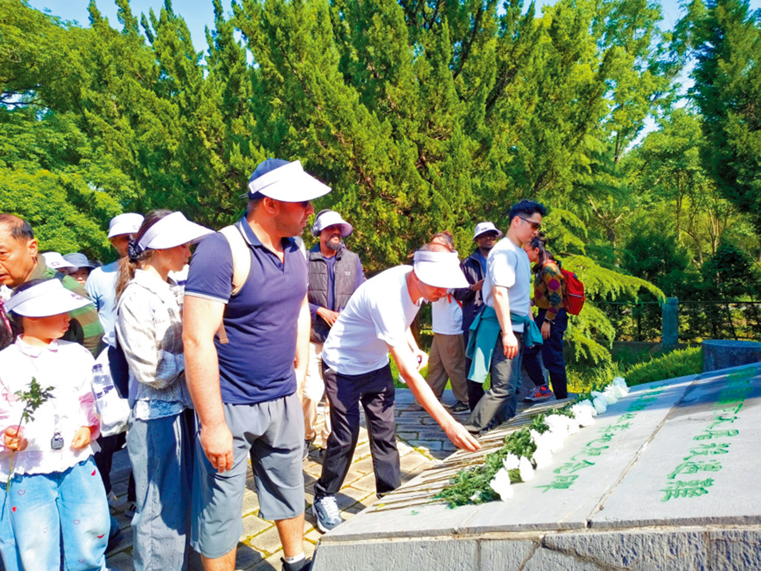 　　圖：中外人士依次向南京大屠殺遇難同胞東郊叢葬地紀念碑敬獻鮮花。\大公報記者賀鵬飛攝