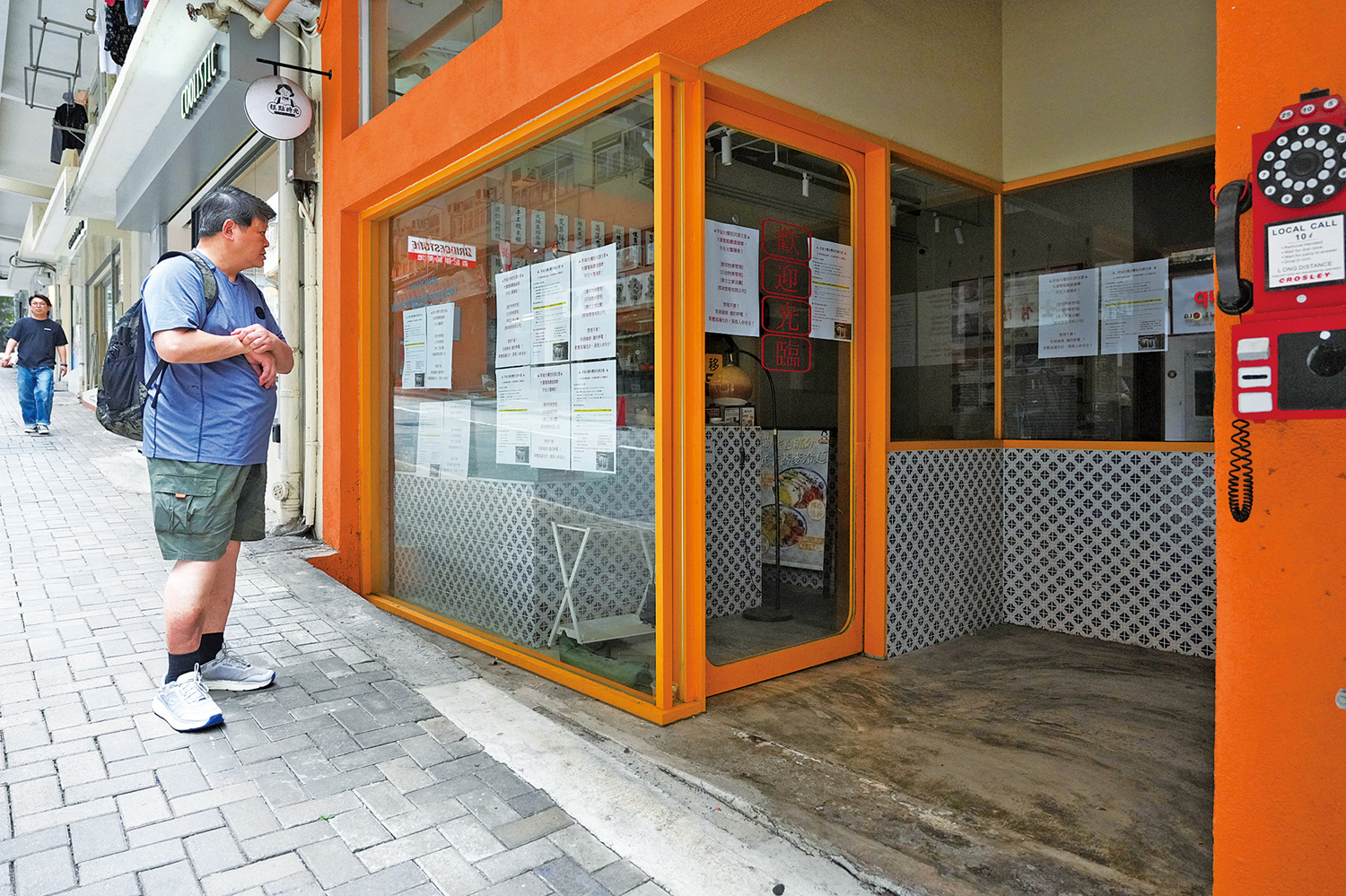 　　圖：北角幸福大樓地下兩間店舖停電逾半個月，商戶在門外張貼相關告示，街坊駐足查看。\大公報記者攝