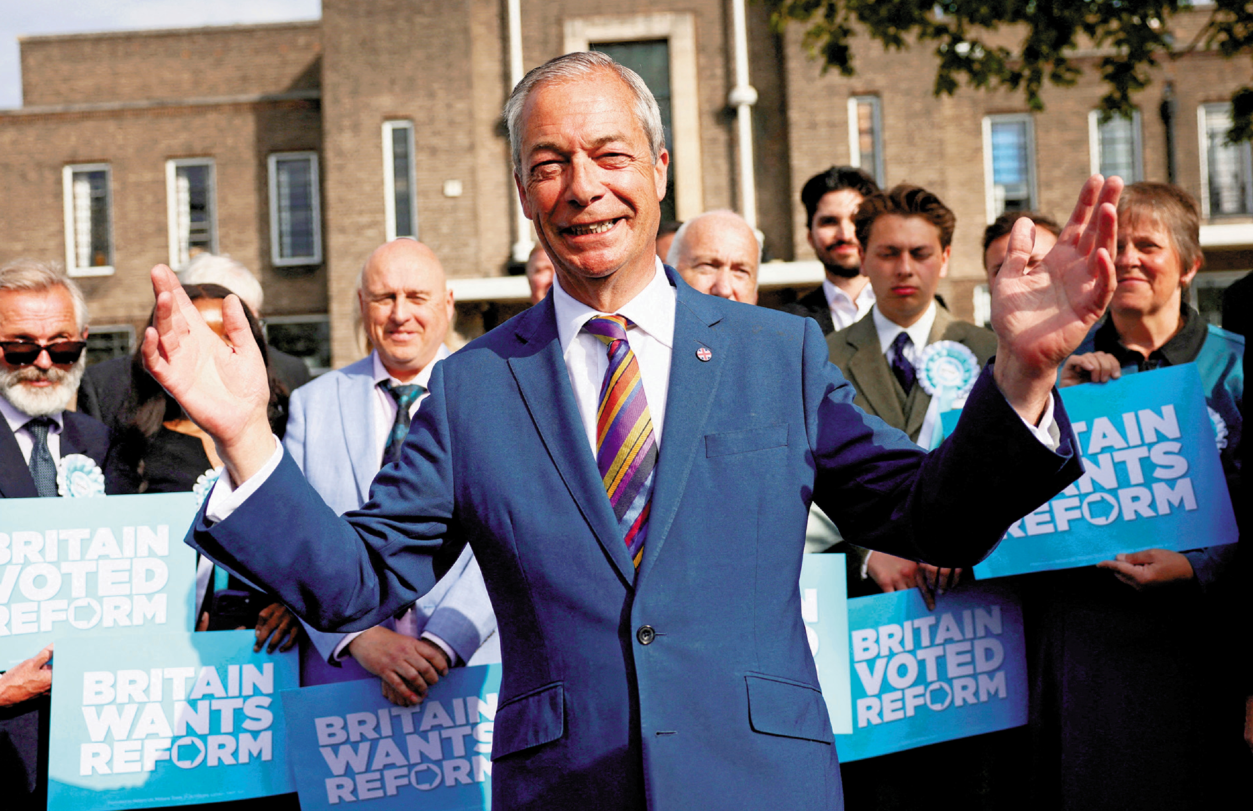 　　圖：英國改革黨黨魁法拉奇8日與新當選的議員合照。\路透社