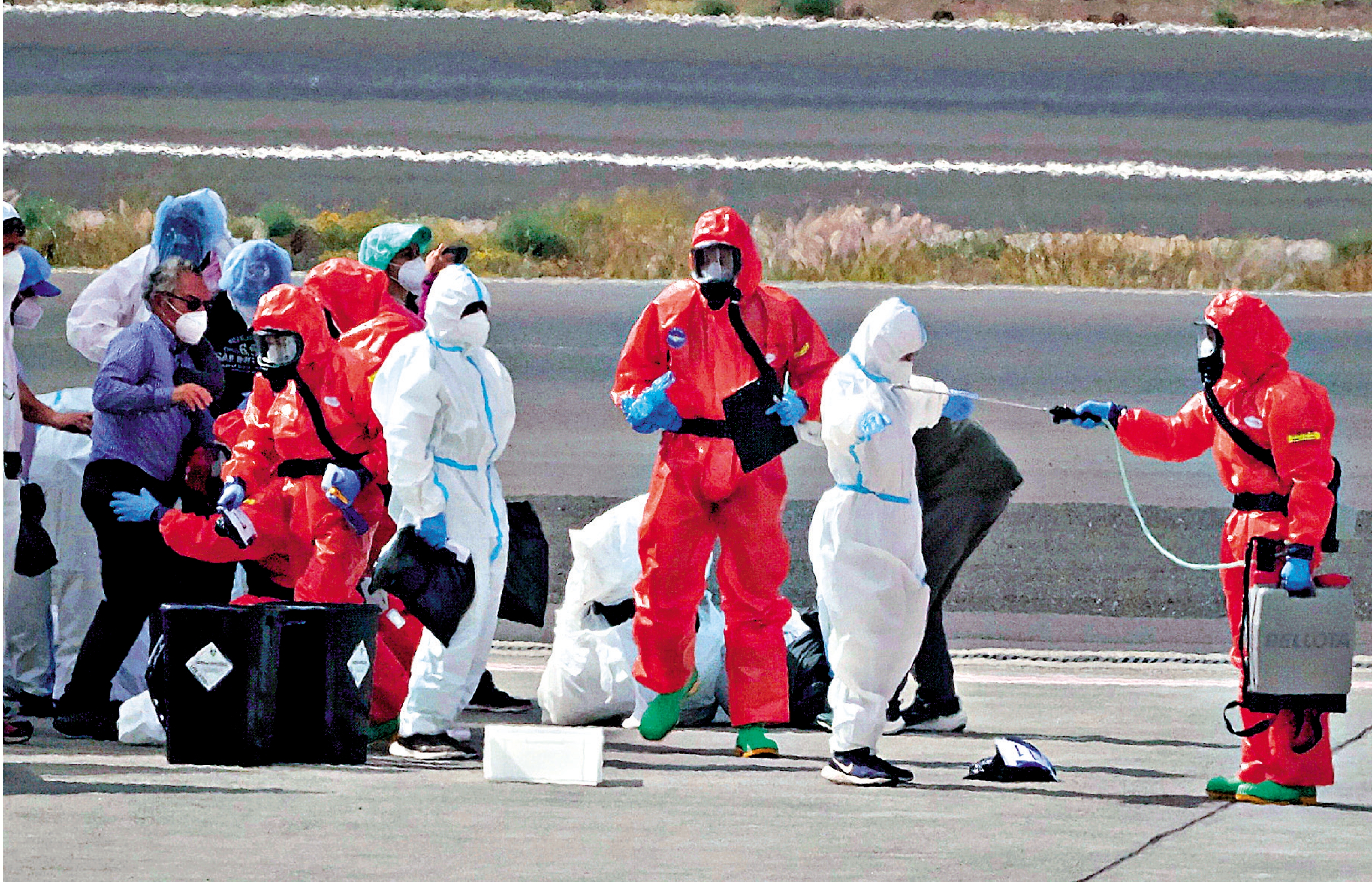 　　圖：「洪迪厄斯」號郵輪乘客10日在西班牙特內里費機場登機回國前接受消毒。\美聯社