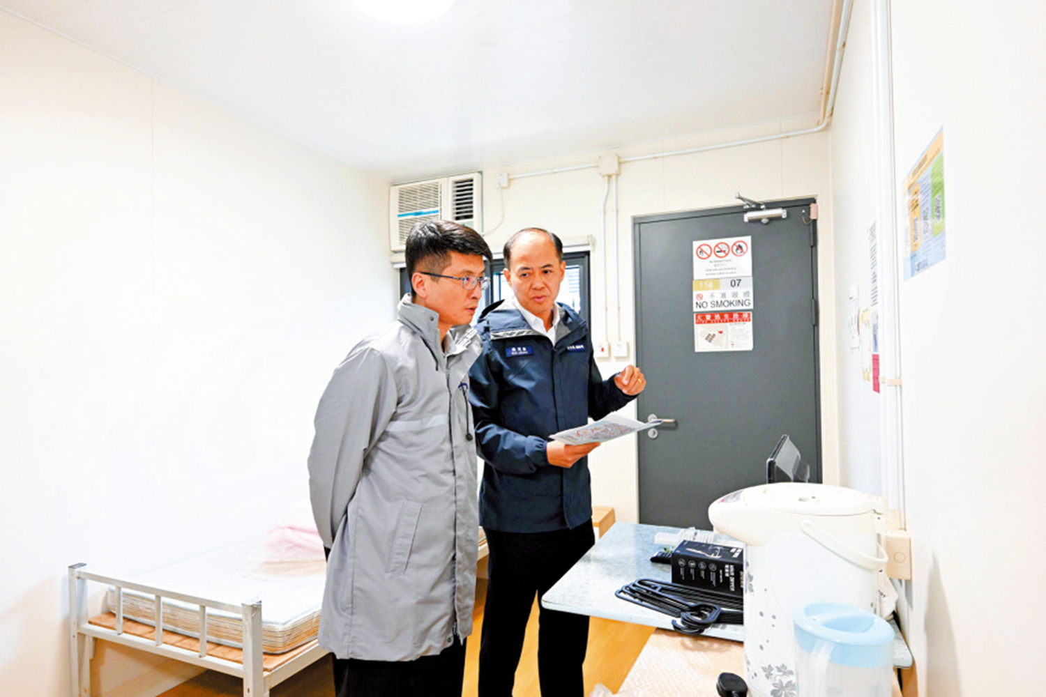 　　圖：衞生防護中心緊急應變及項目管理處主任梁耀康（左）與民眾安全服務處總參事梁冠康巡視竹篙灣社區隔離設施。