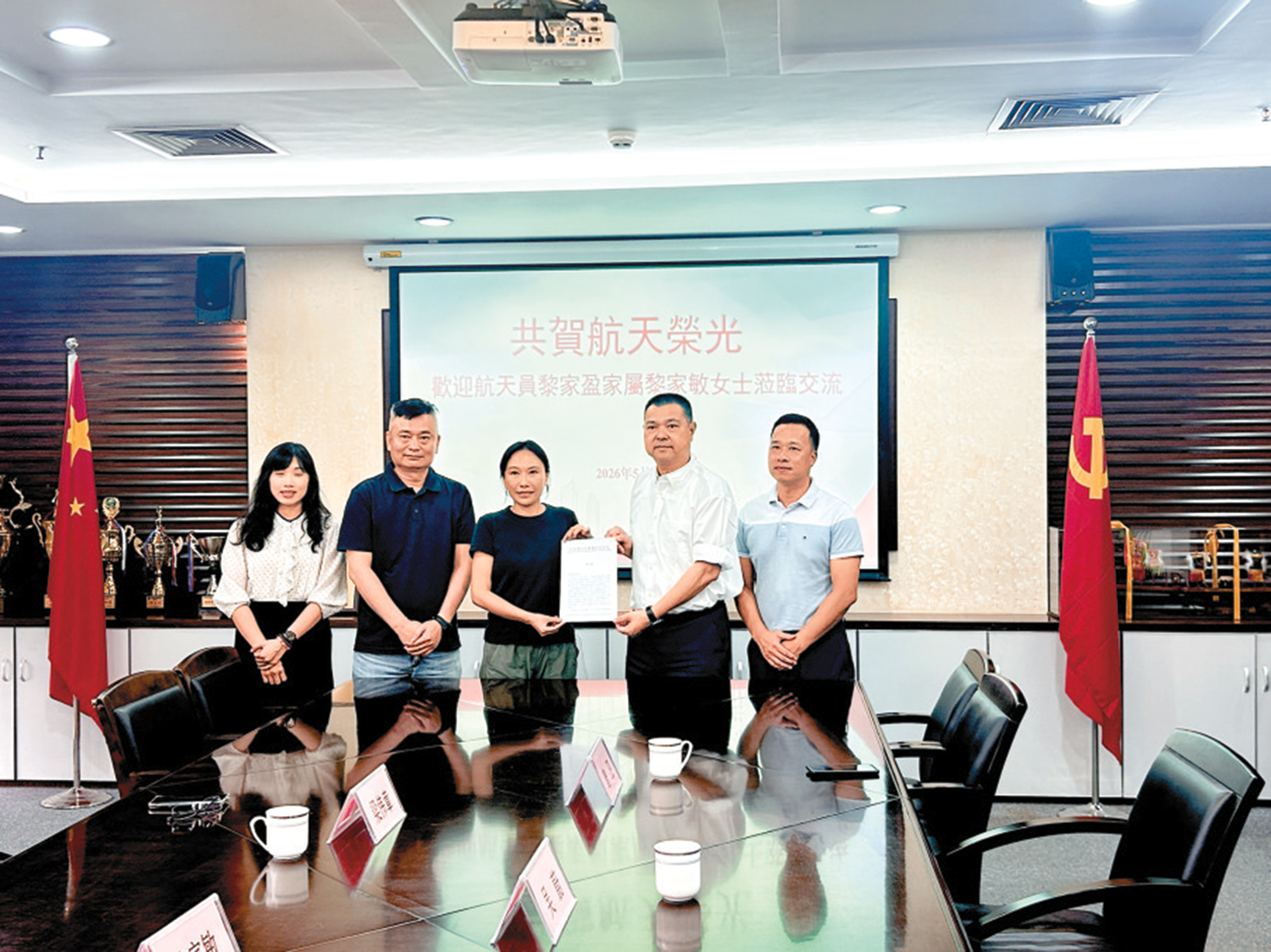 　　圖：黎家盈家鄉順德區委區政府向其胞姊黎家敏（中）及家人發祝賀信。\大公報記者敖敏輝攝