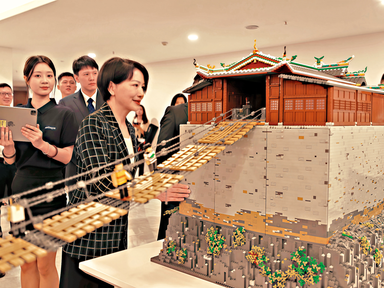 　　圖：江西省委常委、宣傳部部長盧小青（右一）參觀「飛奪瀘定橋」積木交互沙盤，了解數字技術如何助力紅色文化在新時代煥發新的生命力。\大公報記者黃慧攝