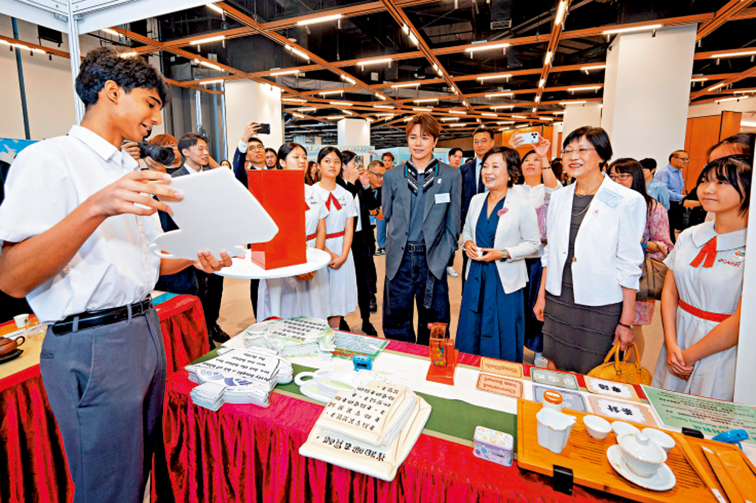 　　圖：蔡若蓮在自主學習語文展覽攤位與學生語文大使互動。