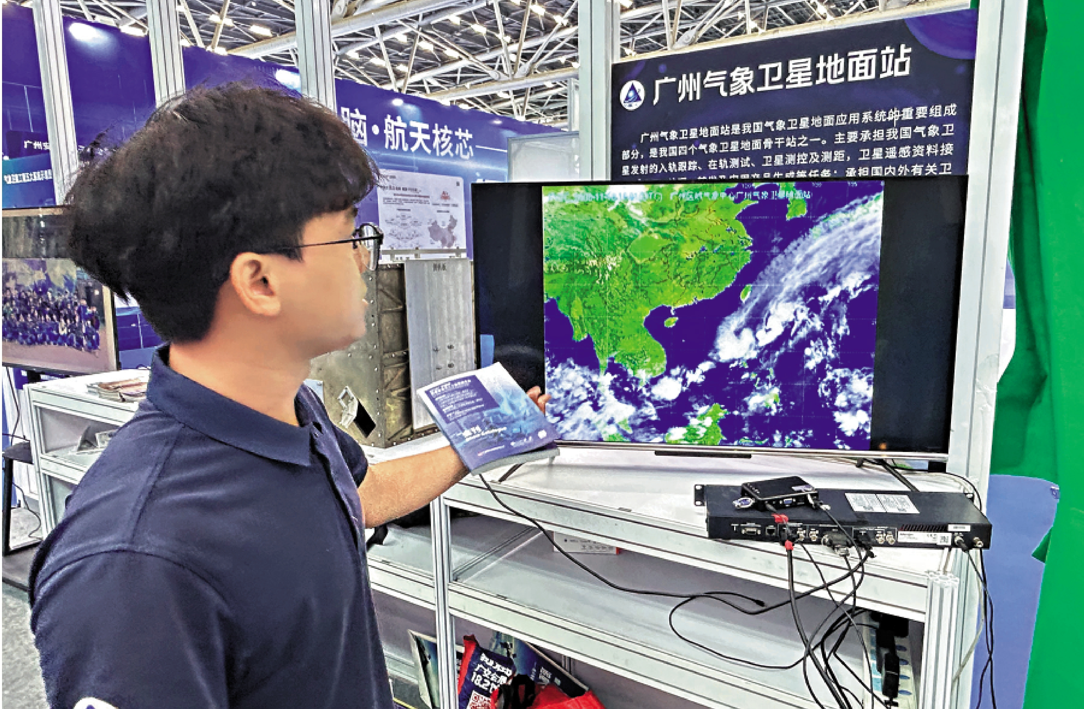 　　圖：AI太空基地展位工作人員展示廣州氣象衛星地面站工作原理。\大公報記者敖敏輝攝