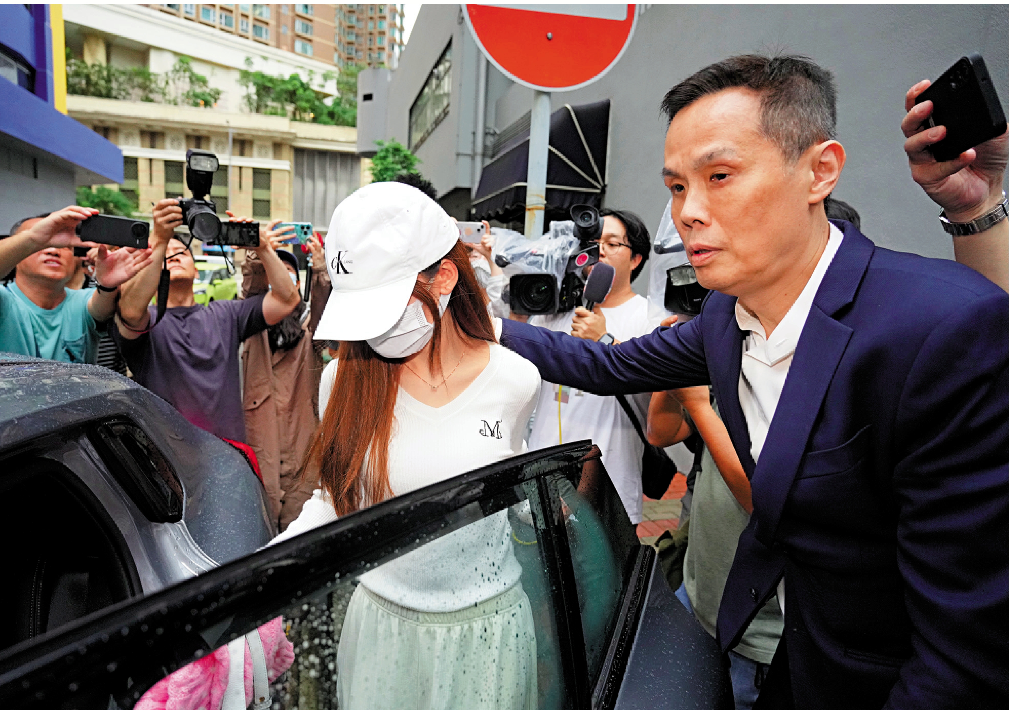 　　圖：涉事女實習醫生（戴帽者）昨午獲保釋後離開長沙灣警署。\大公報記者麥潤田攝