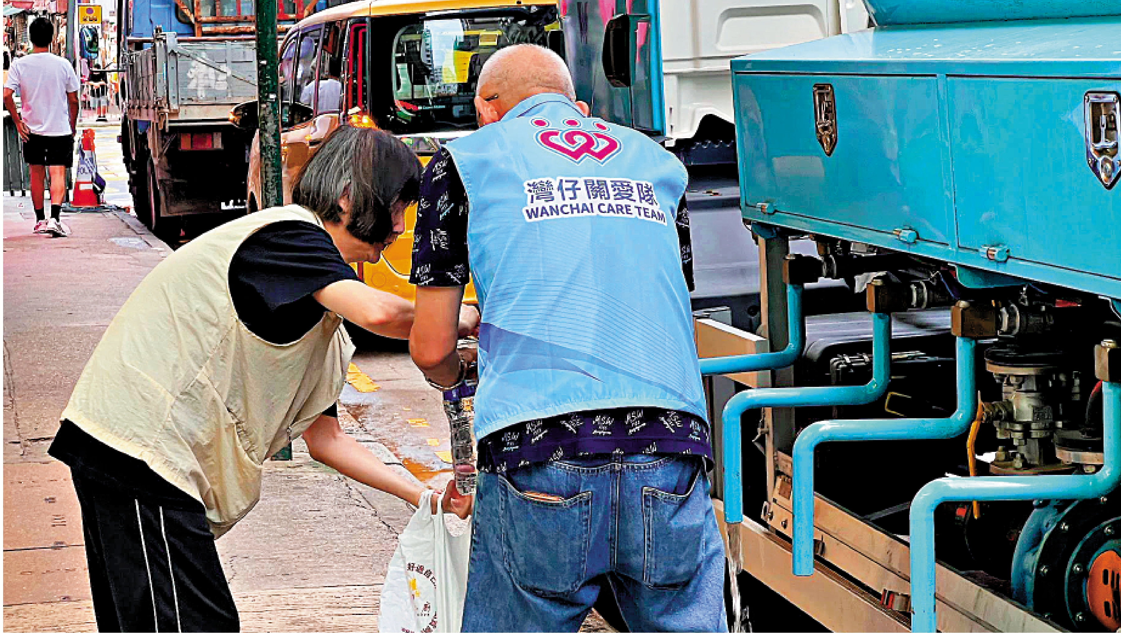 　　圖：關愛隊事發後到受影響大廈派樽裝水，並協助居民下樓取水。