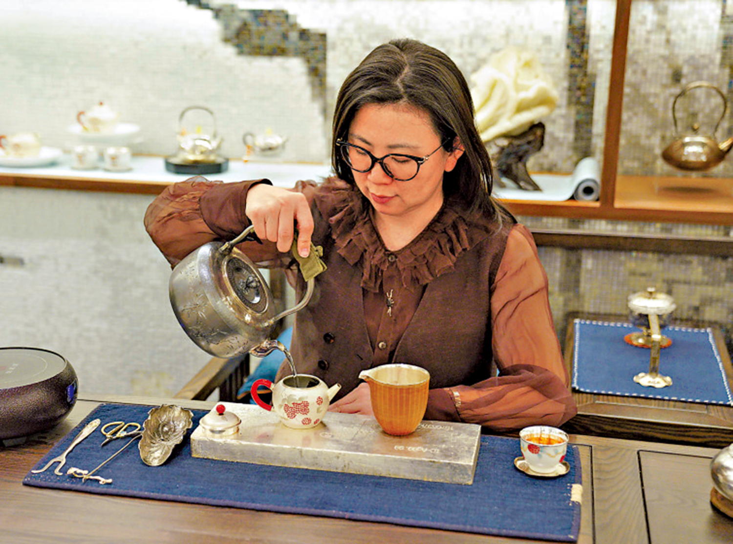 　　圖：張華琴在用手工銀壺泡茶。