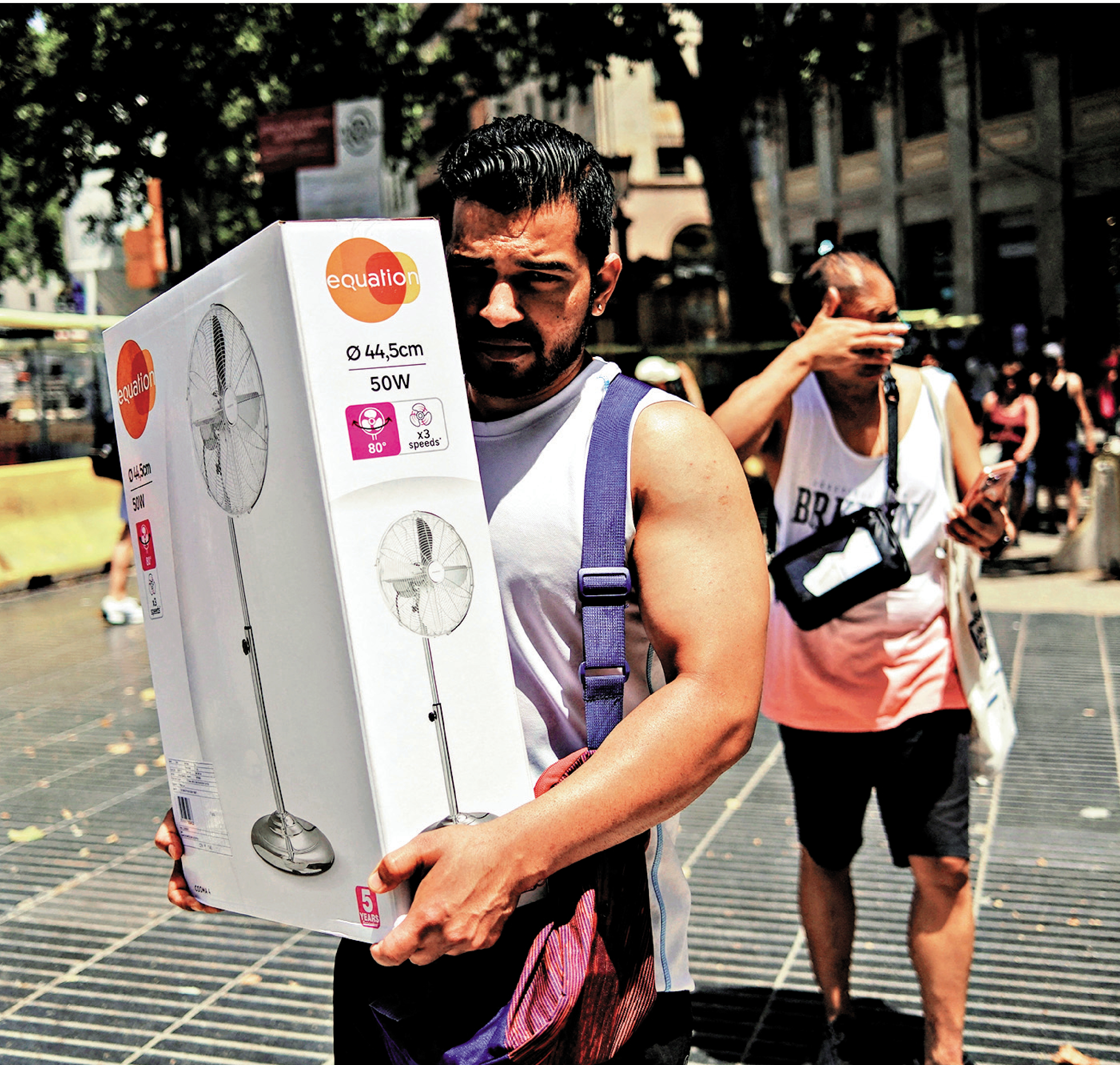 　　圖：熱浪席捲西班牙，巴塞羅那一名男子6月21日購入電風扇。\路透社