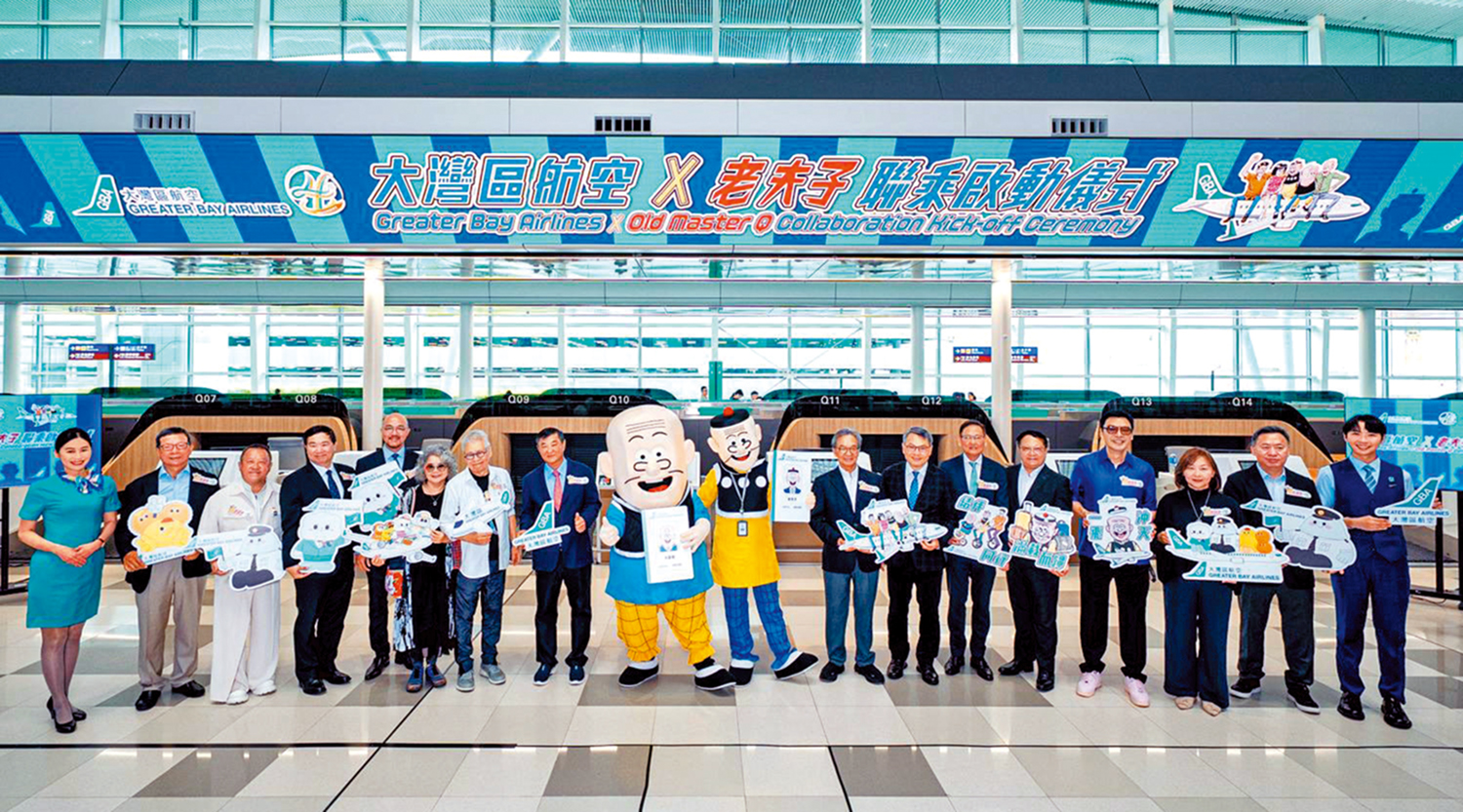 　　圖：「大灣區航空×老夫子聯乘」啟動儀式昨日在機場二號客運大樓舉行，一眾嘉賓與老夫子及大番薯合照。
