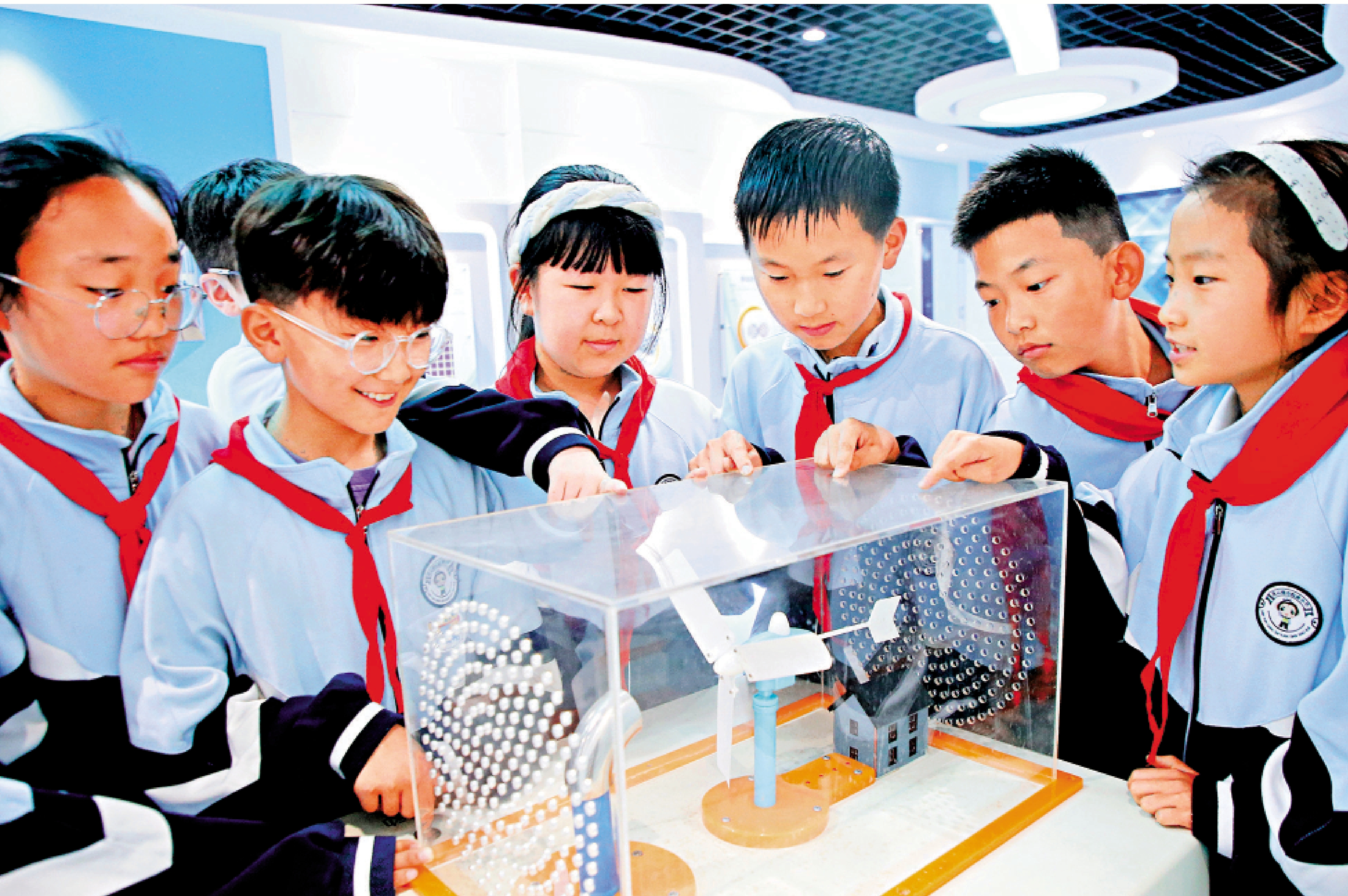　　圖：在江蘇省連雲港市院前小學，學生在校科技館觀看「風力發電」裝置。\新華社