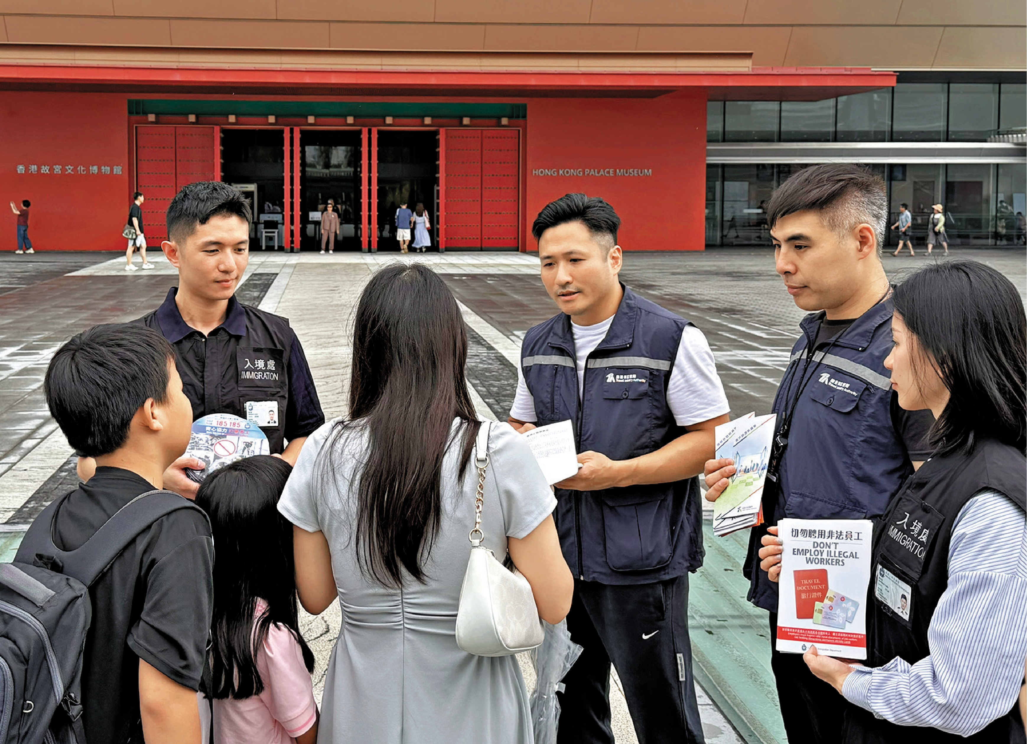 　　圖：入境處在西九文化區向遊客派發單張，提醒切勿使用非法導遊服務。