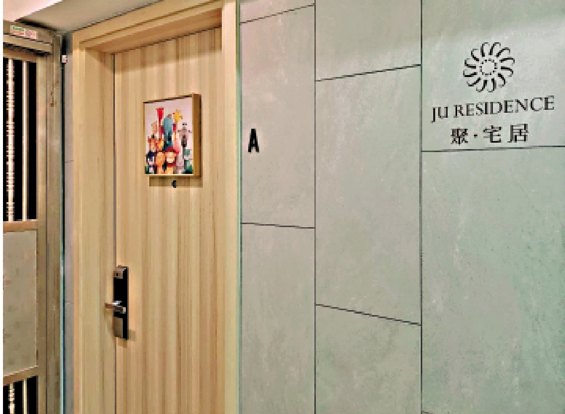 　　圖：灣仔軒尼詩道已獲認證的簡樸房單位，牆上有「聚·宅居」字樣。\大公報記者王香安攝