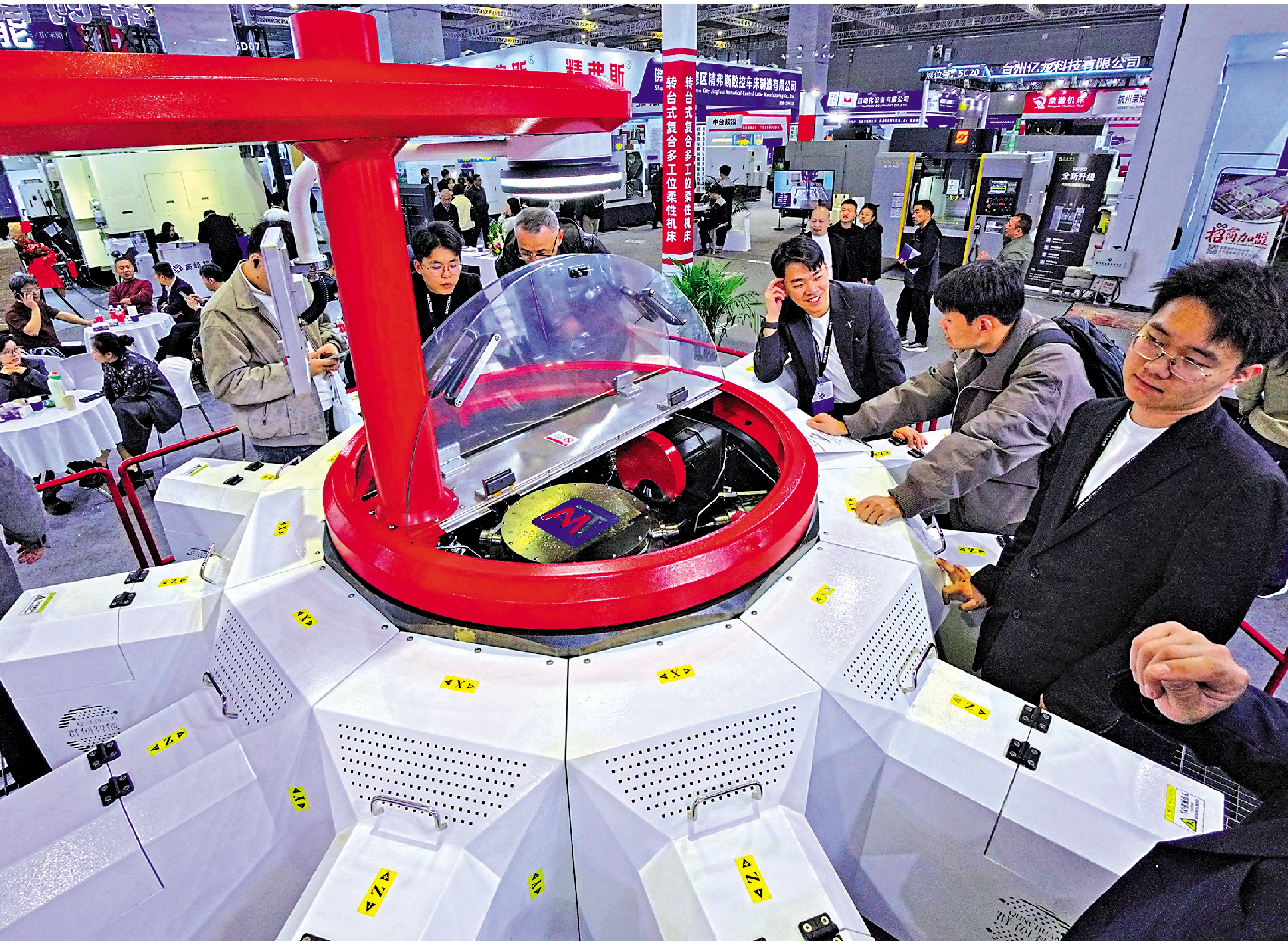　　圖：今年，我國超重型高端工業母機實現關鍵技術突破，補齊大型重載精密加工短板。圖為第11屆上海國際機床展上，參觀者在一款轉台式多工位柔性複合機床展品旁觀看交流。\新華社