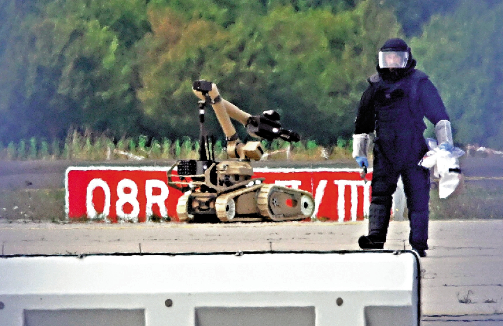 　　圖：一名技術人員5日在萊比錫—哈雷機場與拆彈機器人一起合作拆彈。\美聯社