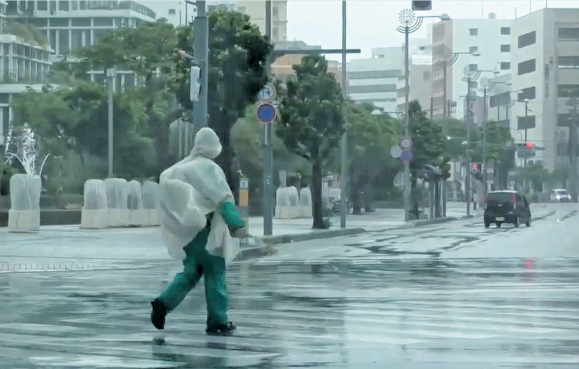 　　圖：颱風「白海豚」8日逼近日本沖繩那霸市，行人冒雨行走。\美聯社