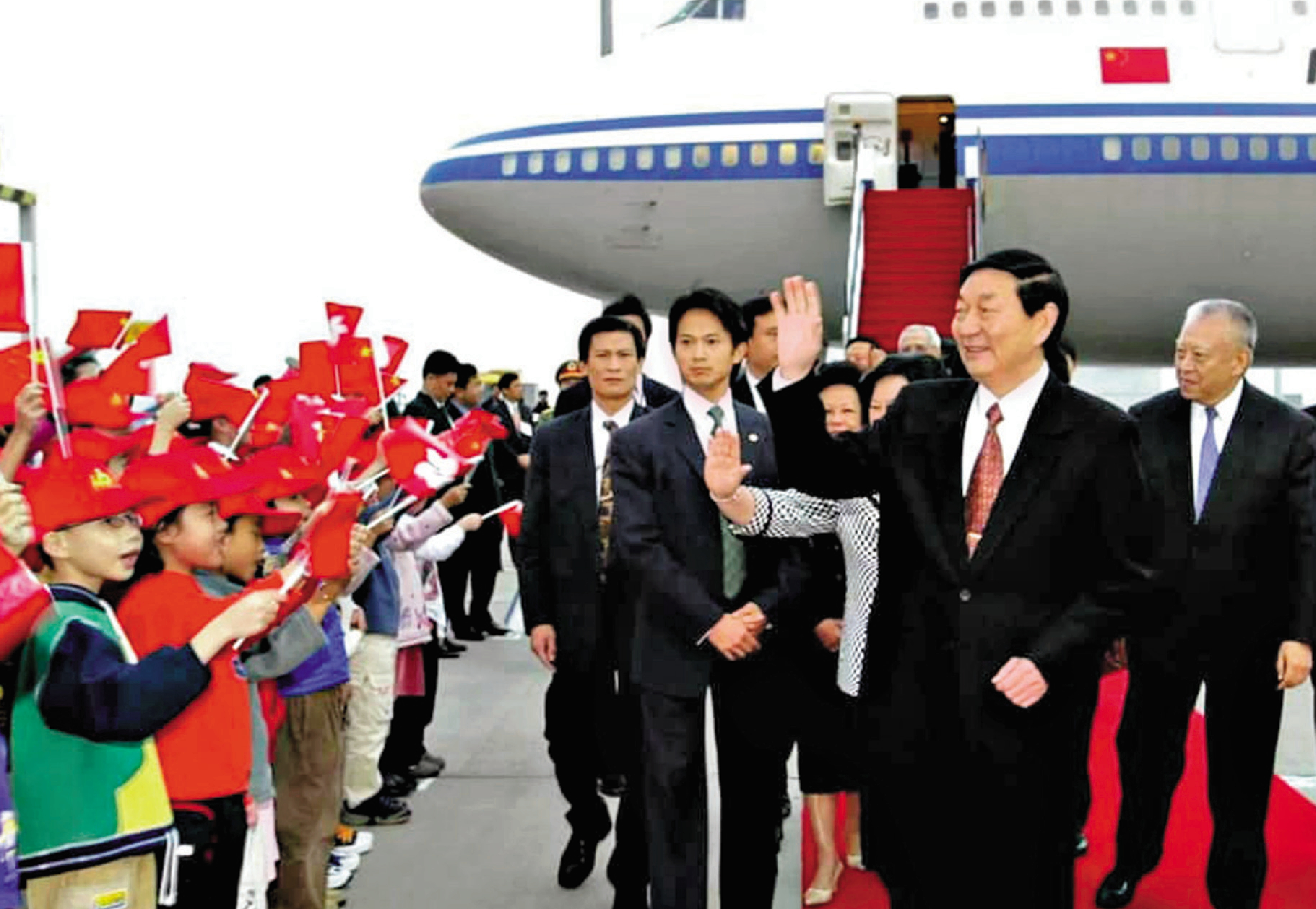 　　圖：2002年11月18日，國務院總理朱鎔基乘專機抵達香港，出席第十六屆世界會計師大會。香港少年兒童在香港國際機場揮舞國旗和特區區旗歡迎朱鎔基。