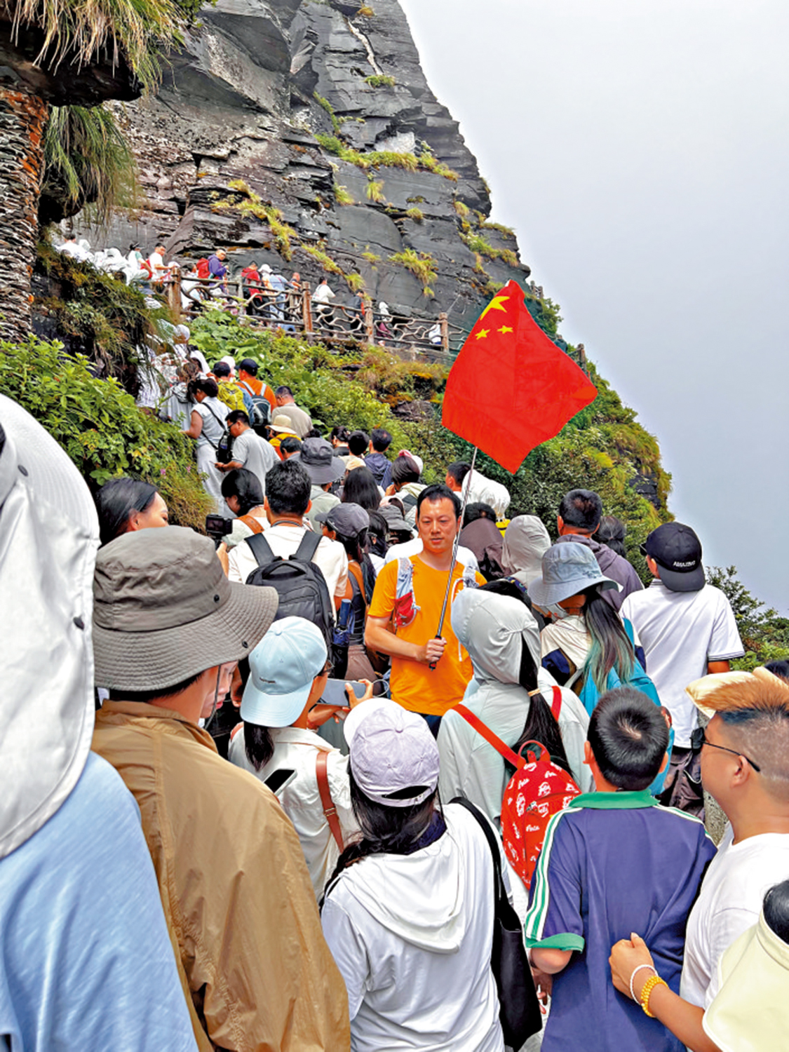 　　圖：來自重慶的遊客邱治興特意帶上國旗來攀登梵淨山。\大公報實習記者施宏咪攝